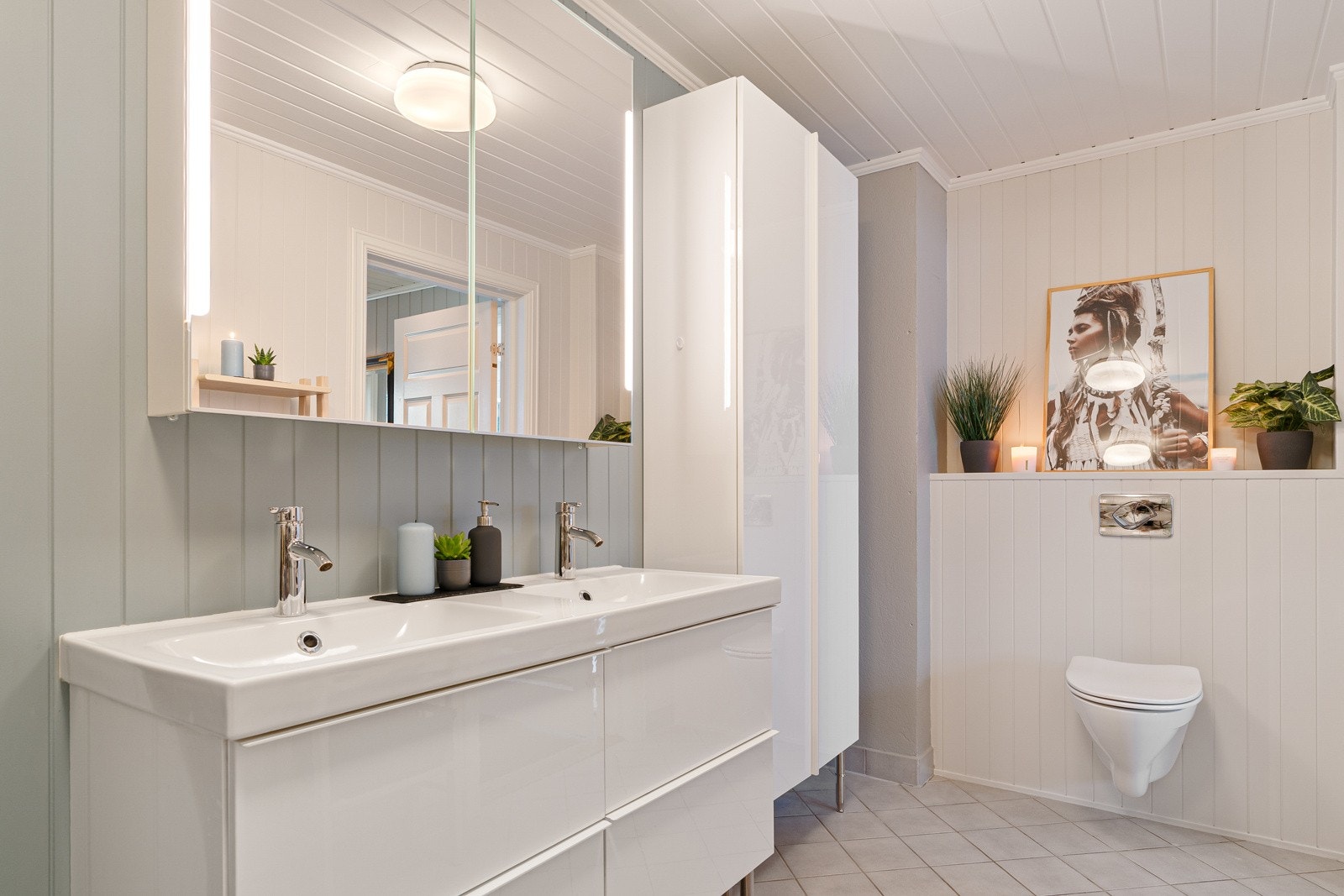 Romslig bad med dobbel servant og gode oppbevaringsløsninger samt vegghengt klosett. Galleribilde