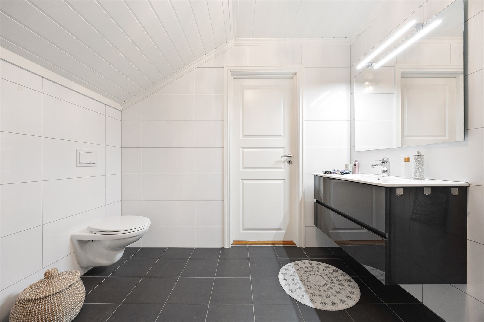 Baderomsinnredningen består av servant med skuffeseksjon, dusjsone med innfellbare dusjvegger og vegghengt toalett. Galleribilde