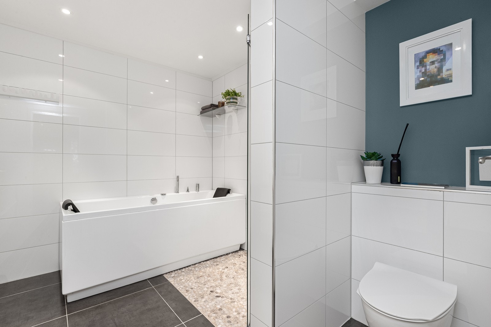 Badet er flislagt og har, som alle gulv i boligen vannbåren varme uten om tilbygget som har elektrisk gulvarme. Galleribilde