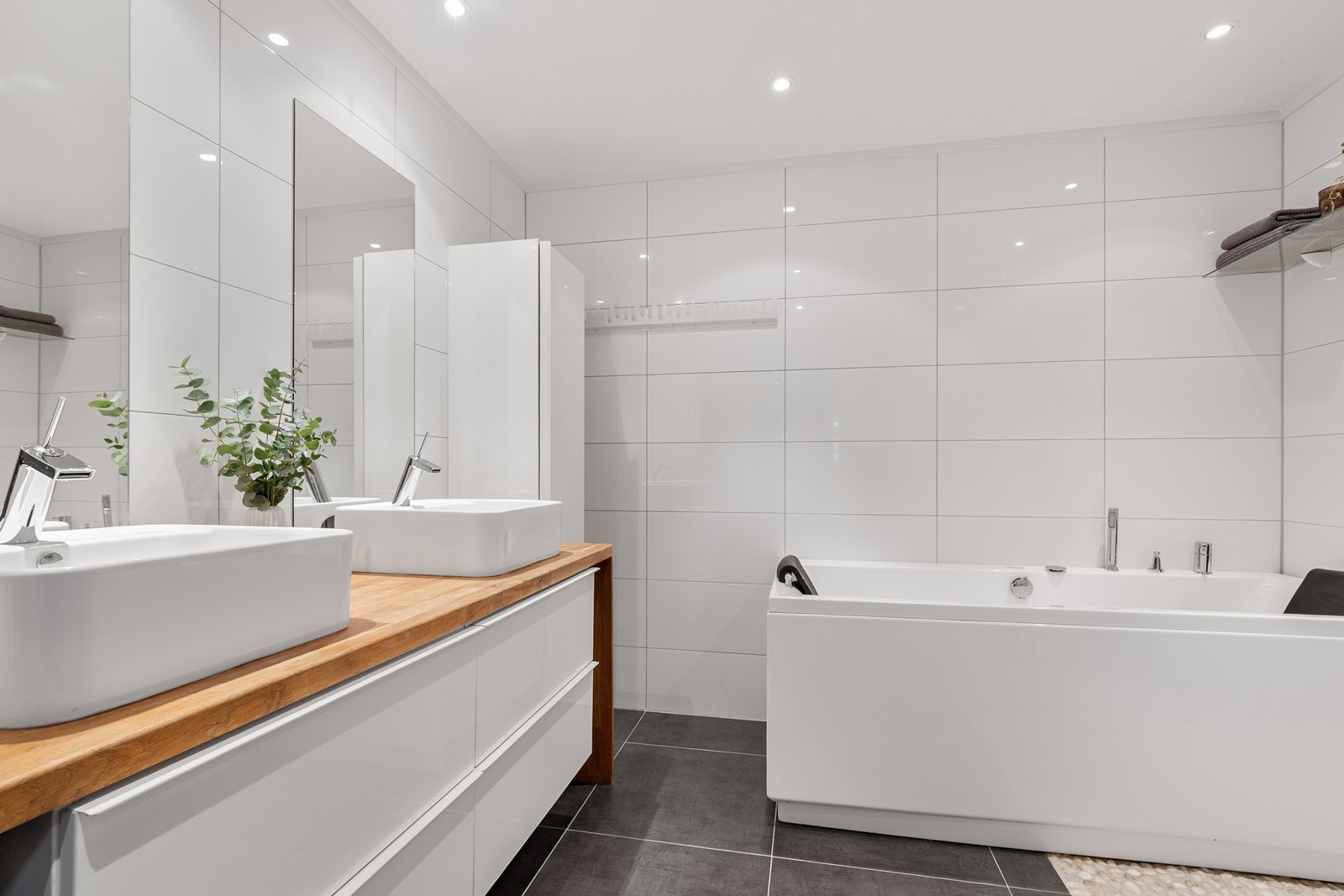 Hovedbadet i første etasje er romslig med en moderne innredning med to servanter. Galleribilde