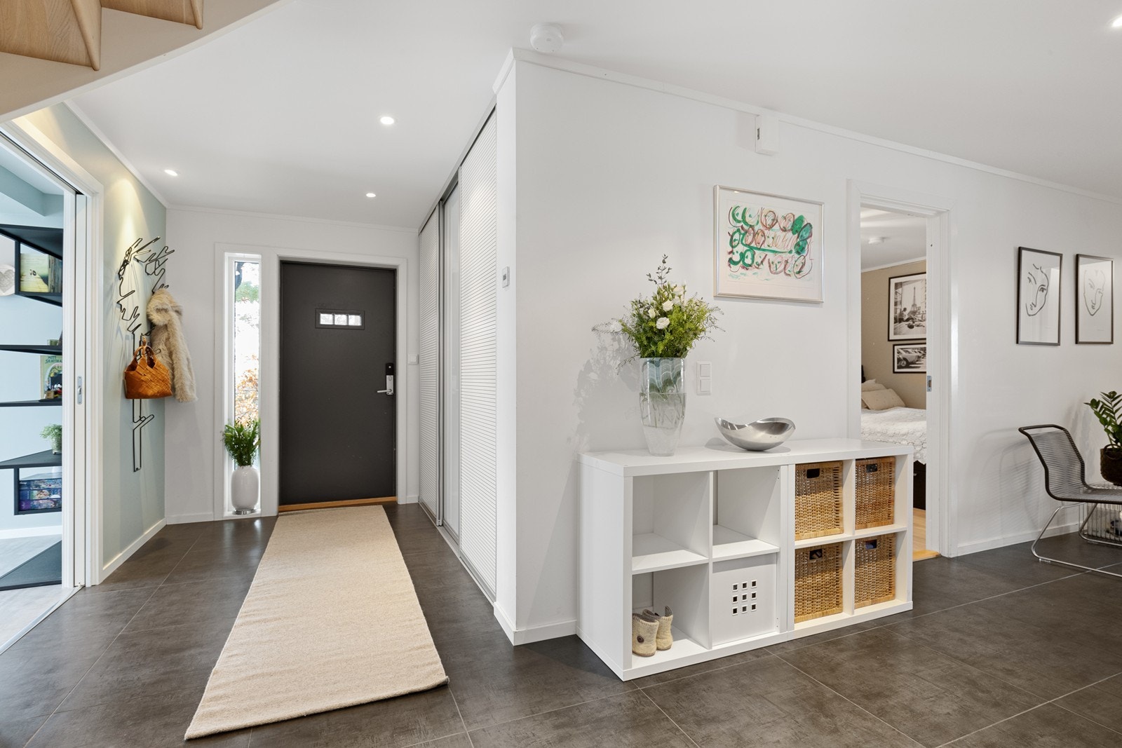 En luftig entré/hall med heldekkende skyvedørsgarderobe. Galleribilde