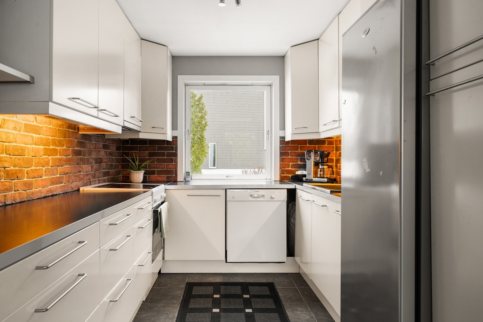 Kjøkkenet er utstyrt med glatte fronter, laminat benkeplate, nedfelt vask i kompositt, kjøkken armatur og opplegg for oppvaskmaskin. Galleribilde