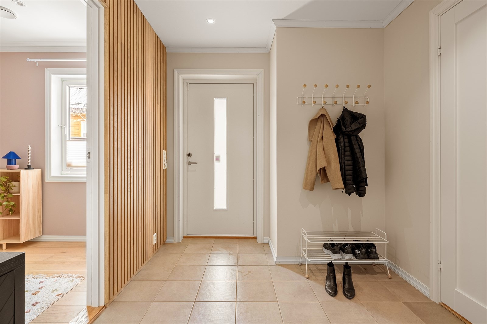 Entréen er romslig med god plass til yttertøy, sko og garderobeløsning. Spileveggen i eik gir en innbydende og varm velkomst til boligen Galleribilde