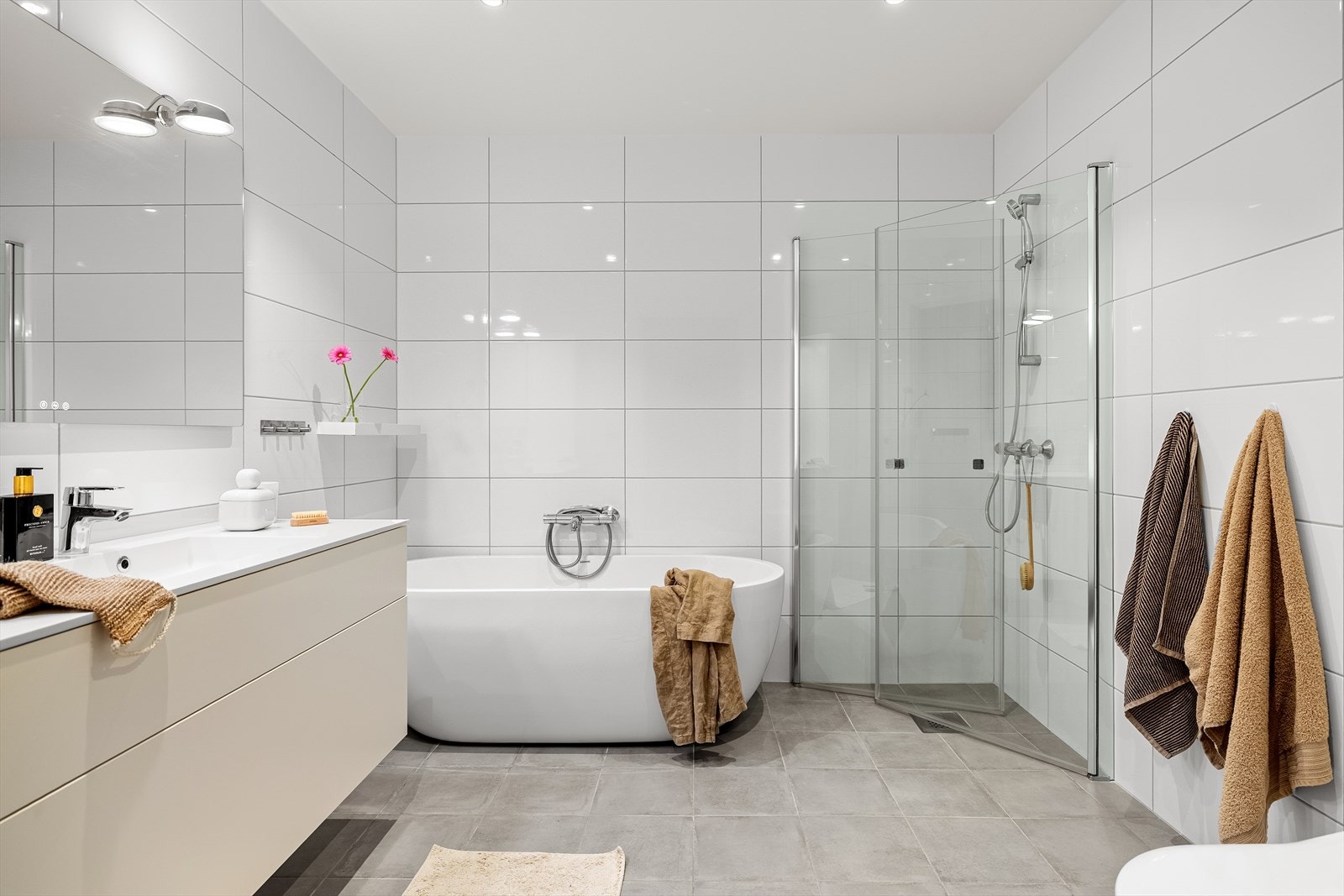 Det romslige hovedbadet i 1. etasje har flislagte vegger og gulv med varmekabler som gir en lun og komfortabel følelse. Badet er utstyrt med dusj, badekar, vegghengt toalett og servant med god oppbevaringsplass. Galleribilde