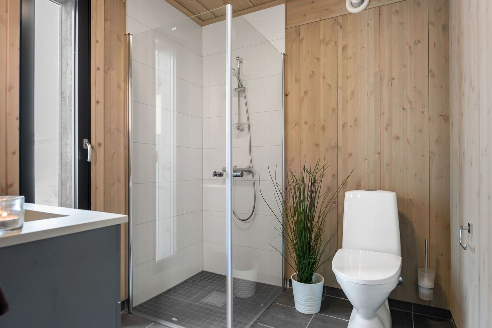 Våre bad leveres nå med storformat fliser i 60x60 cm på både vegger og gulv. Foto med trepanel er fra en eldre modell. Galleribilde