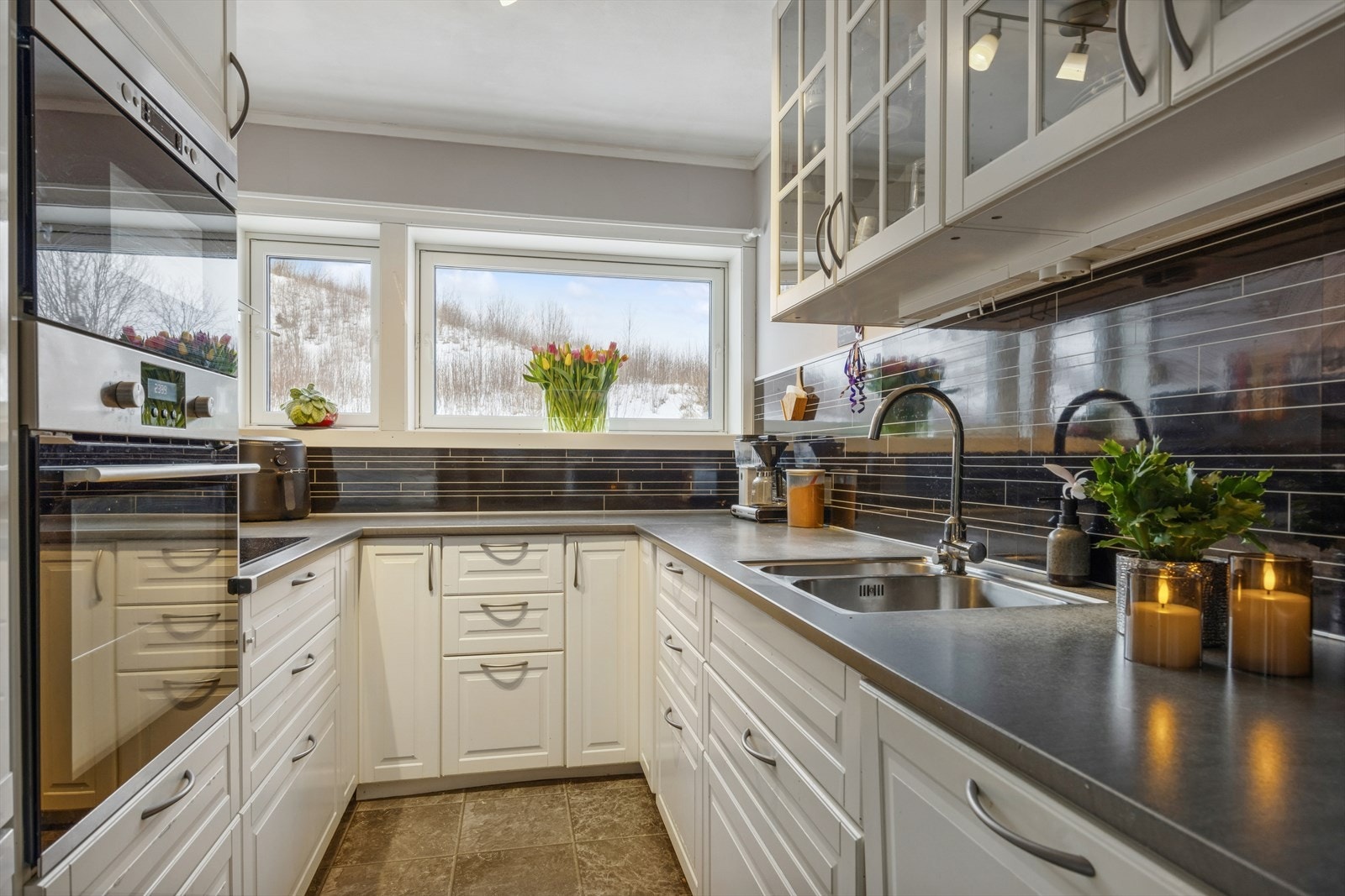 Kjøkkeninnredning med folierte skrog med profilerte fronter og laminert benkeplate. Galleribilde