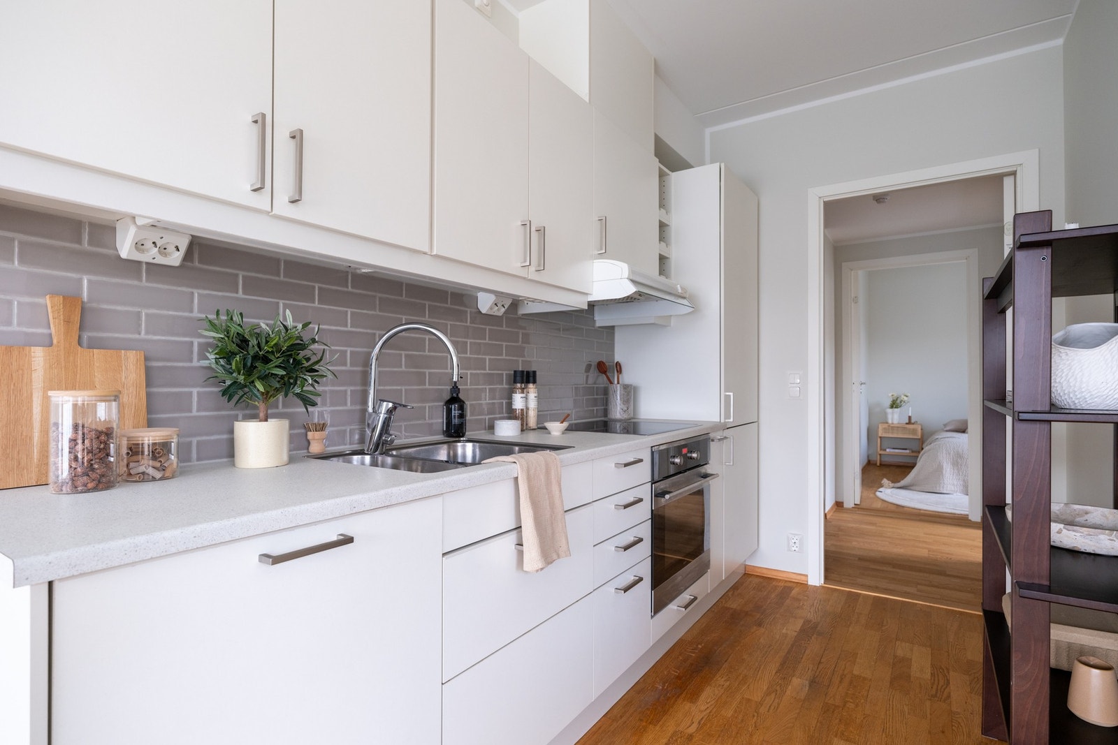 Pent Sigdal-kjøkken i lys, glatt utførelse med laminat benkeplate og nedsenket oppvaskkum med ett-greps blandebatteri. Galleribilde