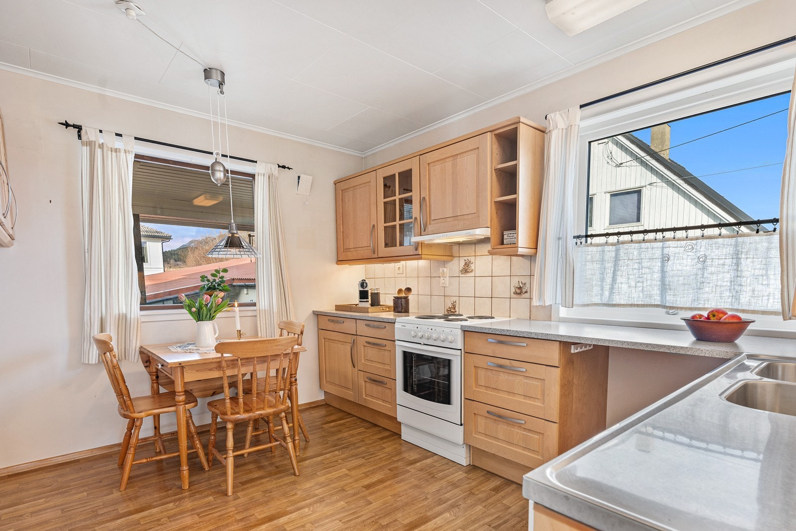 Kjøkkenet er innredet med profilerte fronter og laminat benkeplate. Her er det også god plass til spisegruppe for hverdagsmåltidene. Galleribilde