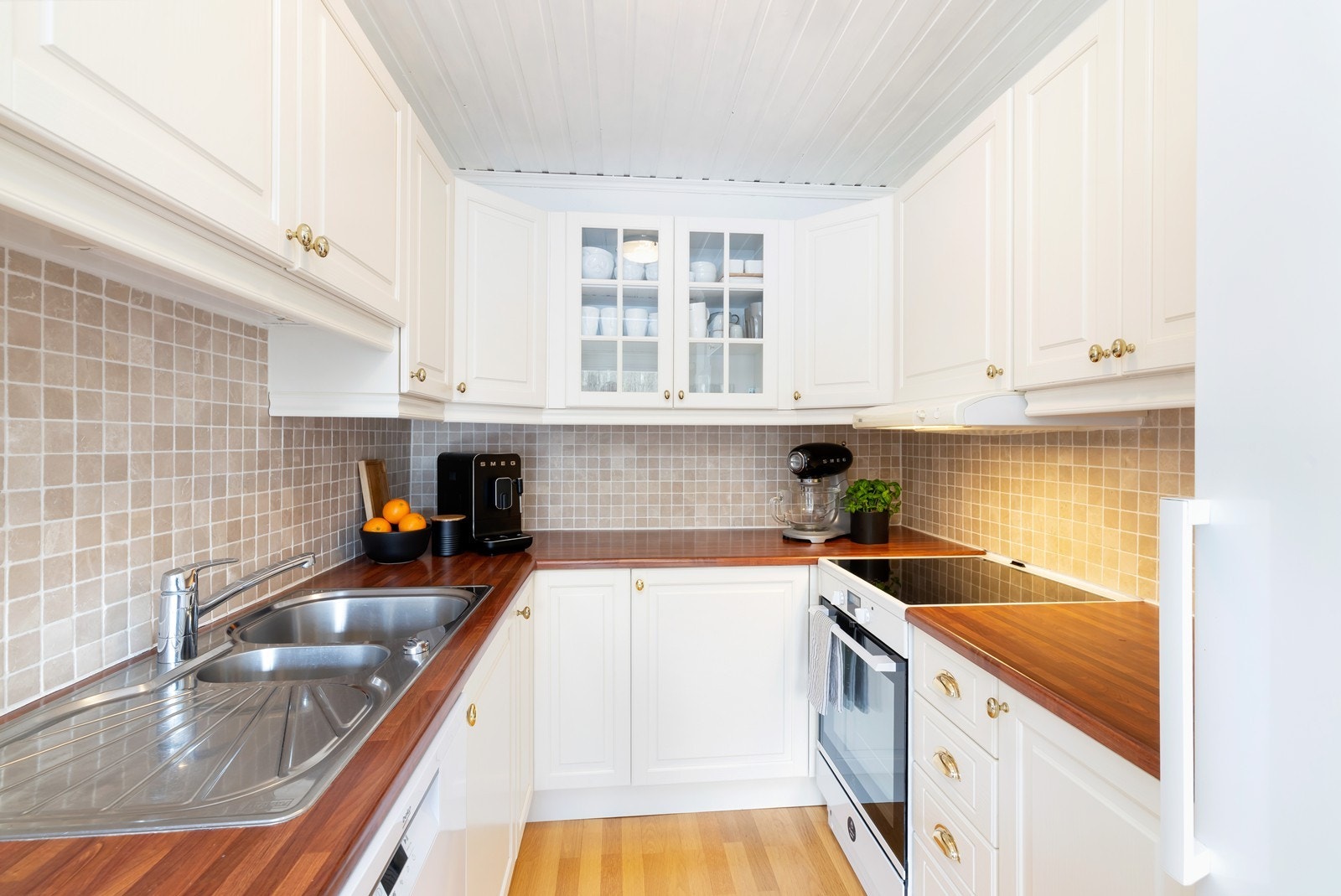 Kjøkken inneholder komfyr, oppvaskmaskin og ett frittstående kjøleskap Galleribilde