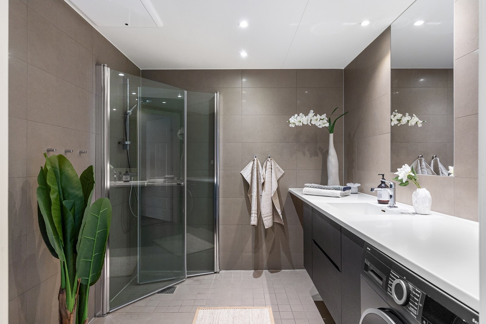 Delikat, flislagt baderom med downlights i himlingen og gulvvarme. Det er også opplegg for vaskemaskin. Galleribilde