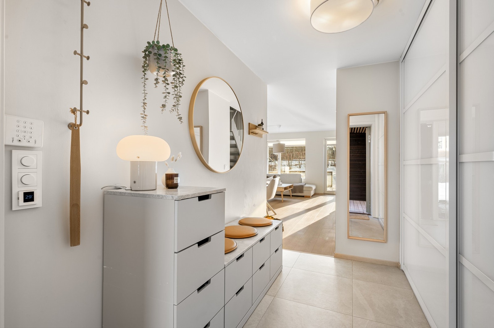 Lys og romslig entré med skyvedørsgarderobe. Flislagt og slitesterkt, med gulvvarme. Galleribilde