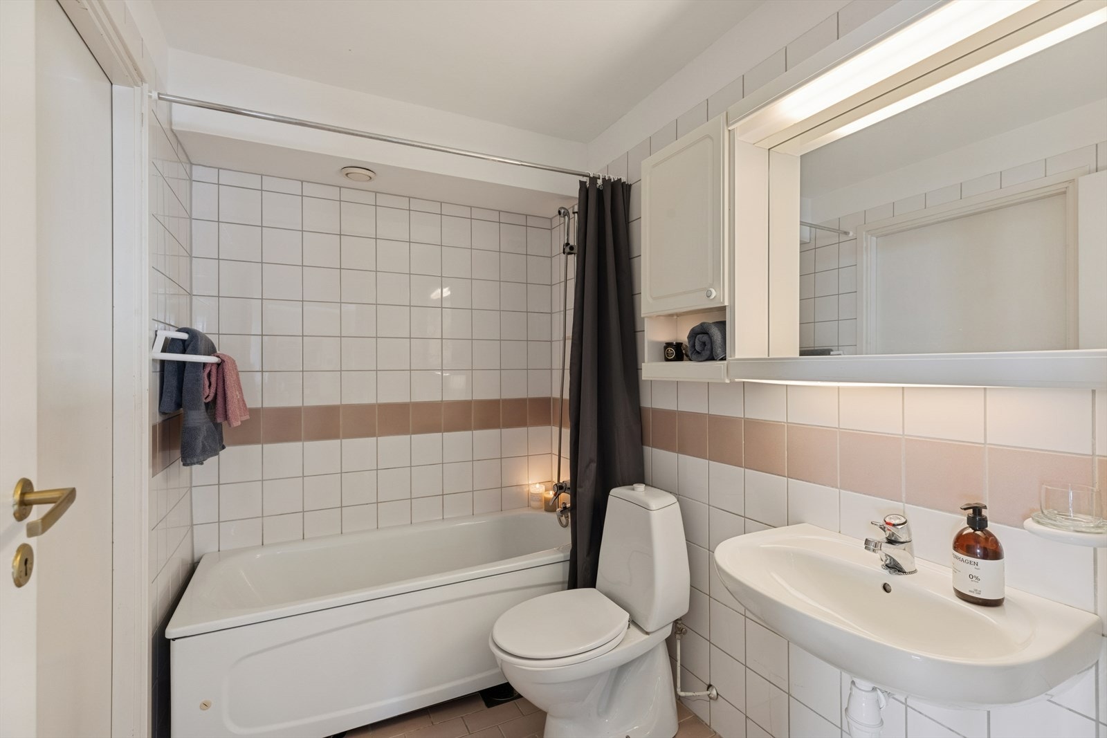 Baderommet er eldre, med delvis flislagte overflater og elektrisk gulvvarme som gir god komfort. Galleribilde