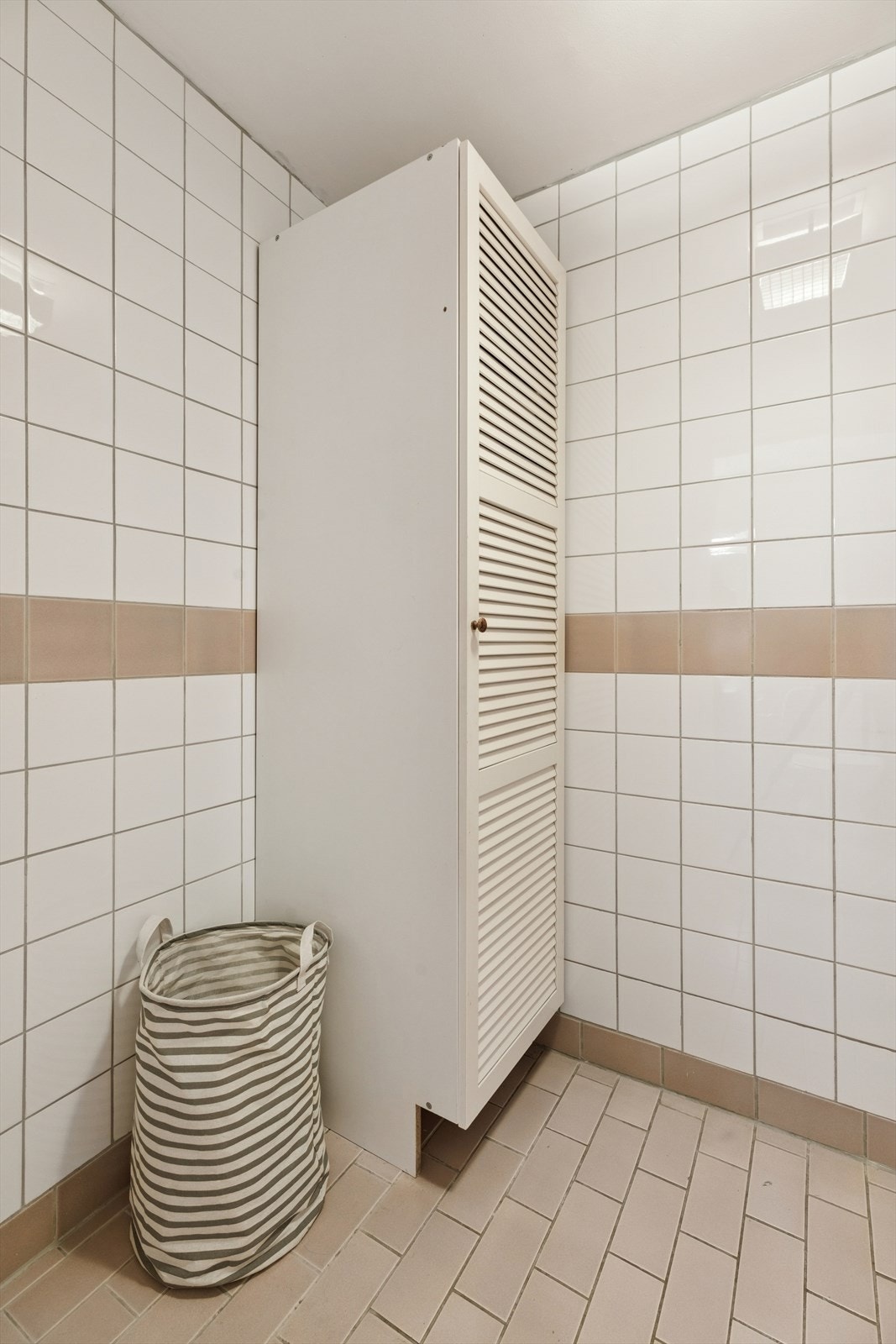 Videre er vaskerommet innredet med et skap for ekstra oppbevaring. Galleribilde