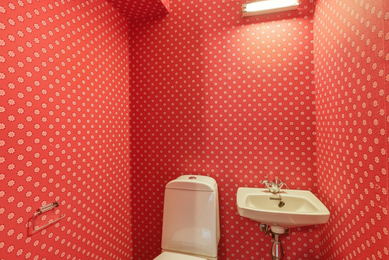 Toalettrom med gulvstående toalett og vegghengt servant. Galleribilde