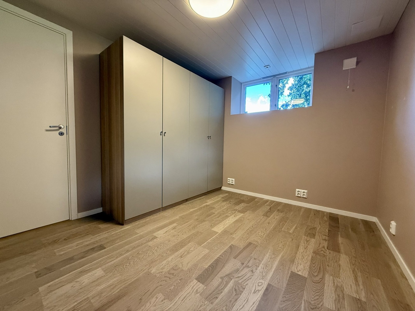 Soverommet i kjeller er av god størrelse og er utstyrt med garderobeskap. Her er det god plass til seng og skrivebord. Parkett på gulv med gulvarme, og tidsmessig farge på vegg. (Ikke søkt/godkjent til varig opphold). Selgers bilde. Galleribilde