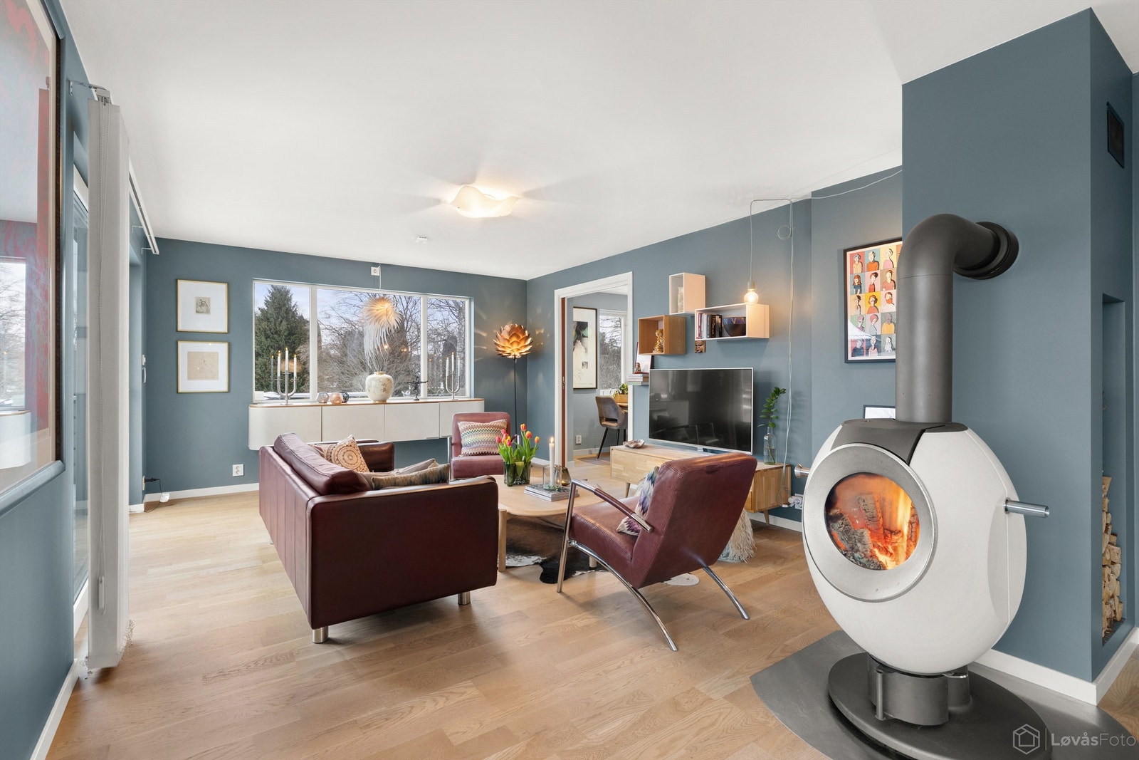 Peisen gir ikke bare varme på kjølige dager, men tilfører også rommet en lun og koselig atmosfære, perfekt for rolige kvelder eller hyggelige stunder med familie og venner. Galleribilde