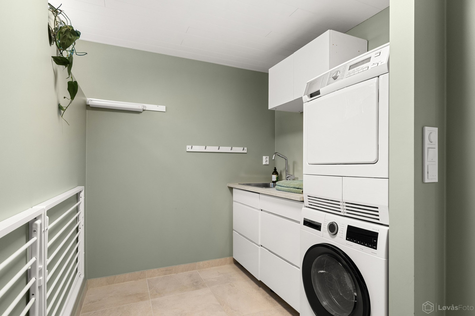 Vaskerommet ble pusset opp i 2023, og fremstår som moderne med flislagt gulv og behagelig gulvvarme. Praktisk innredet med benke- og veggskap for oppbevaring, utslagsvask, opplegg til vaskemaskin og tørketrommel. Galleribilde