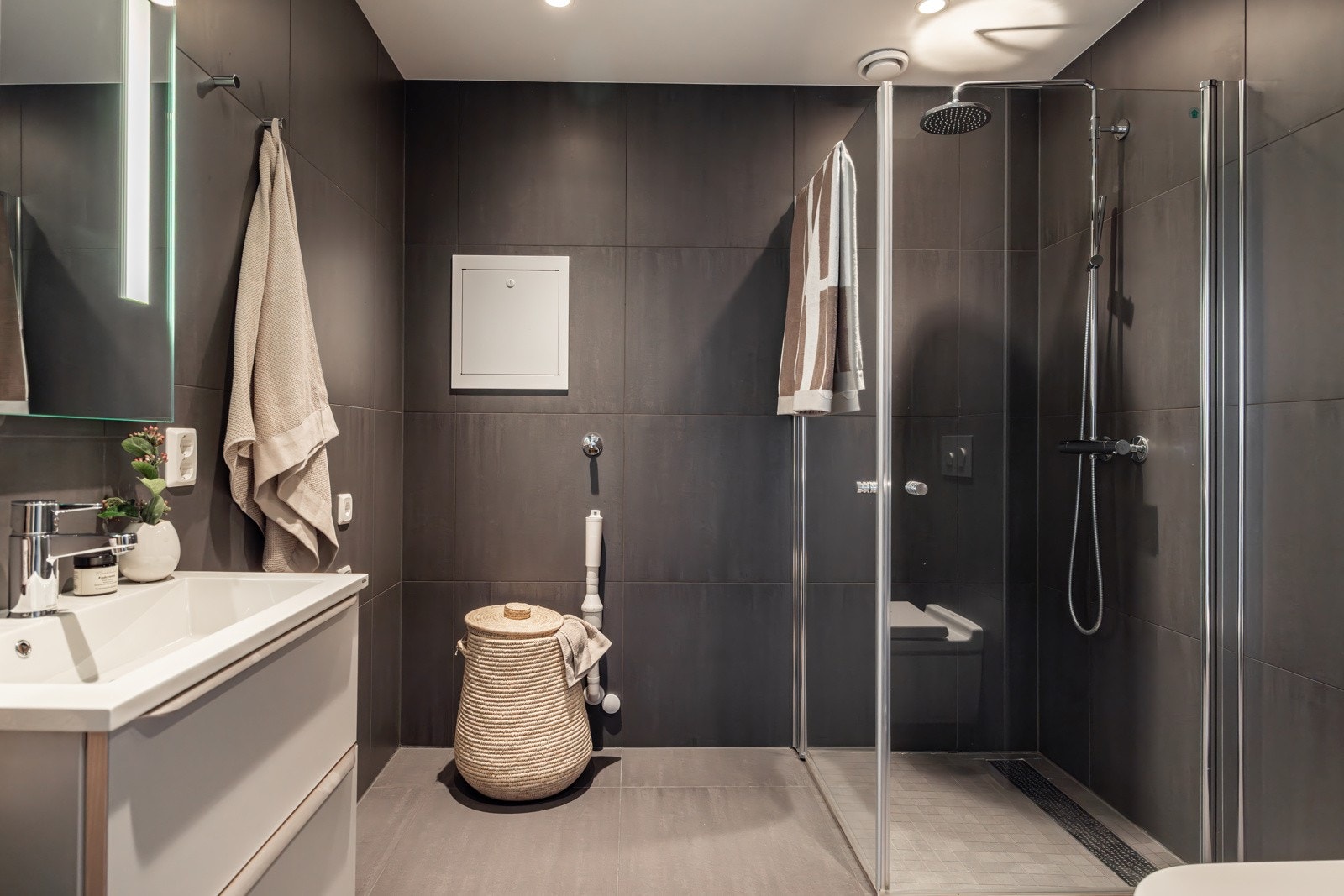 Leiligheten har et stilrent og moderne baderom som ble pusset opp i 2019. I hjørnet av baderommet er det plass og opplegg for vaskemaskin, i tillegg til tørketrommel om ønskelig. Galleribilde