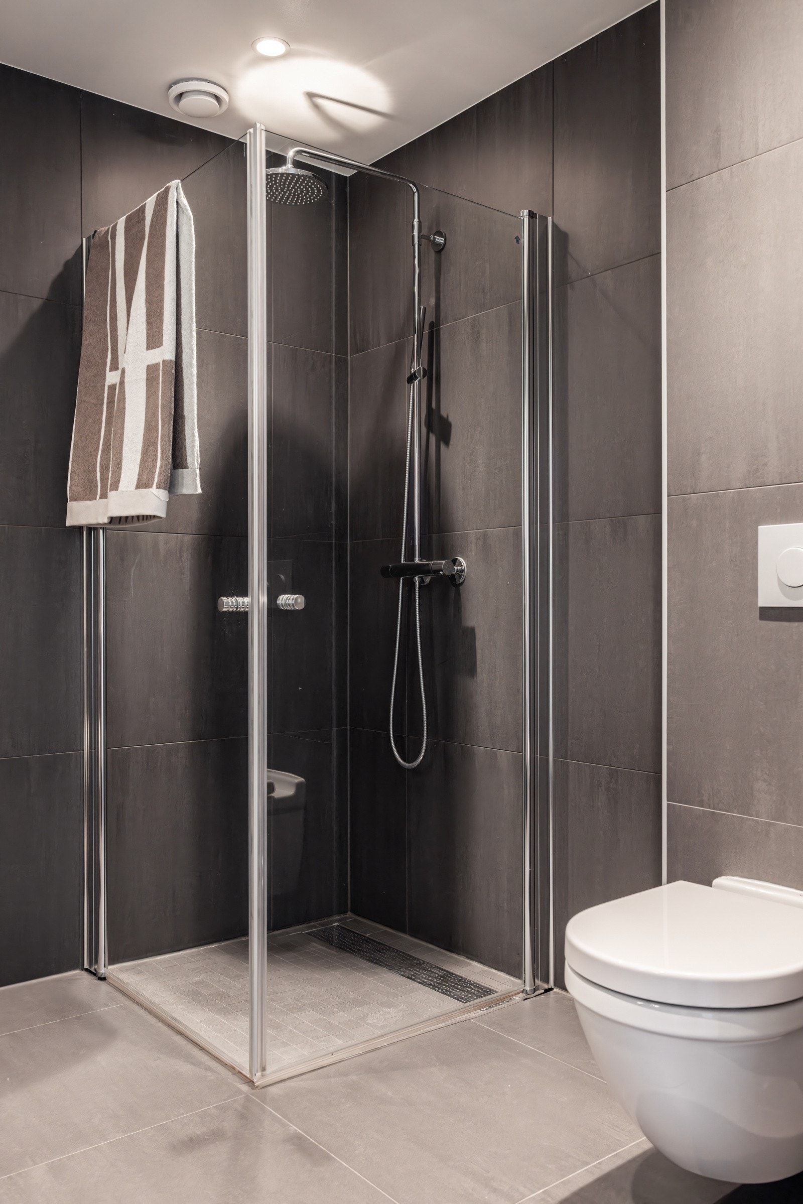 Baderommet er også utstyrt med dusjhjørne med innfellbare glassdører og både hånd- og regnfallsdusj, samt vegghengt toalett. Galleribilde