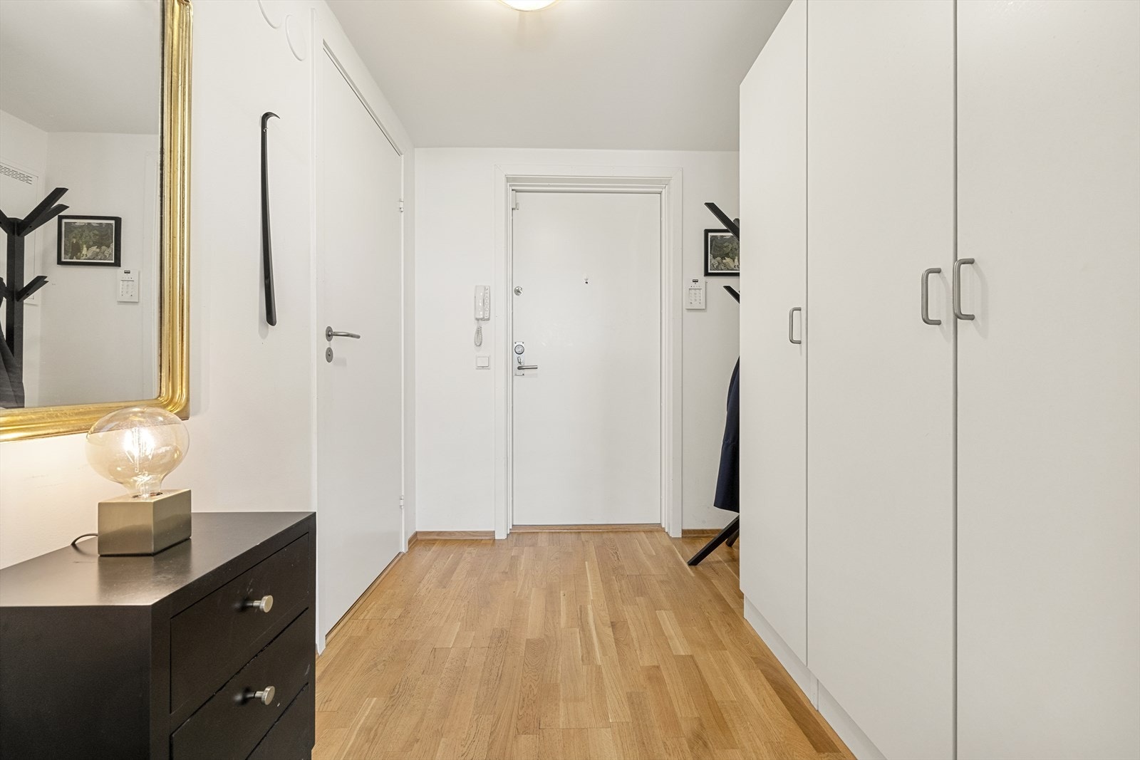 En innbydende entré med plass til oppbevaring av yttertøy og en nedsenket himling. Galleribilde