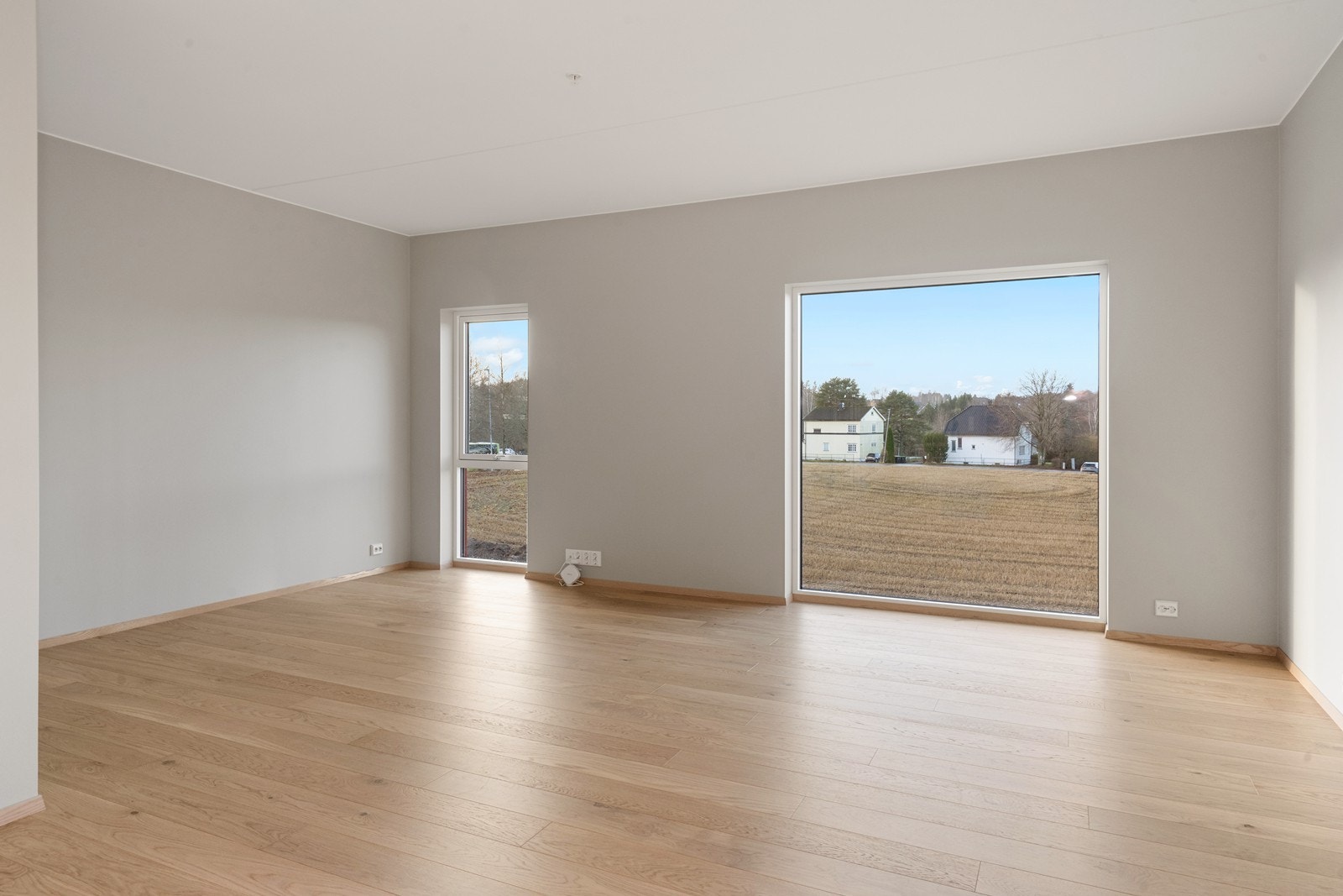 Store vindusflater gir godt utsyn mot grøntområde og mye naturlig lys. Galleribilde