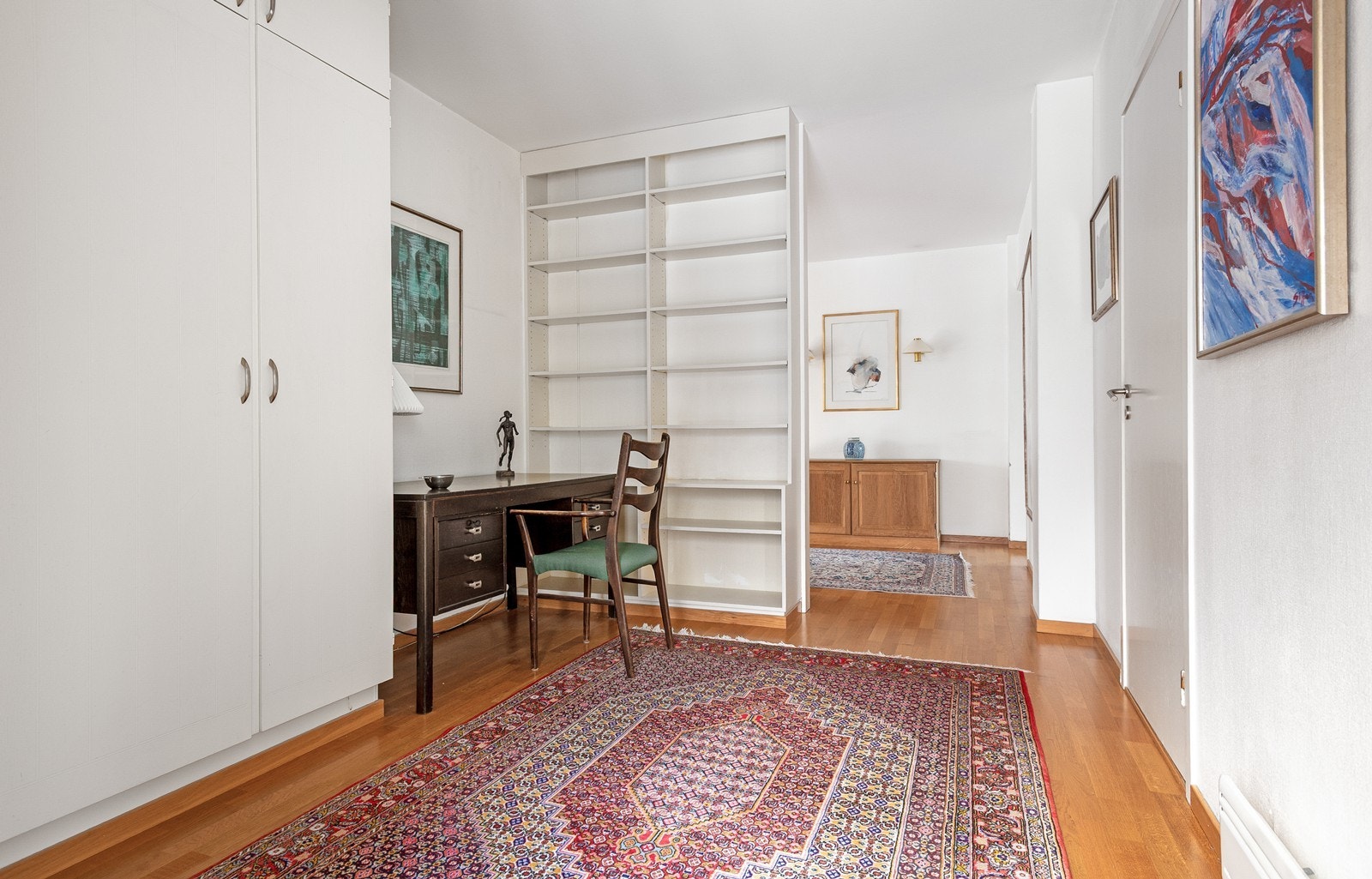 Romslig hall med lys fra entre-gangen, samt direkte inngang til gjeste toalett og godt med skapplass + bokhyller Galleribilde