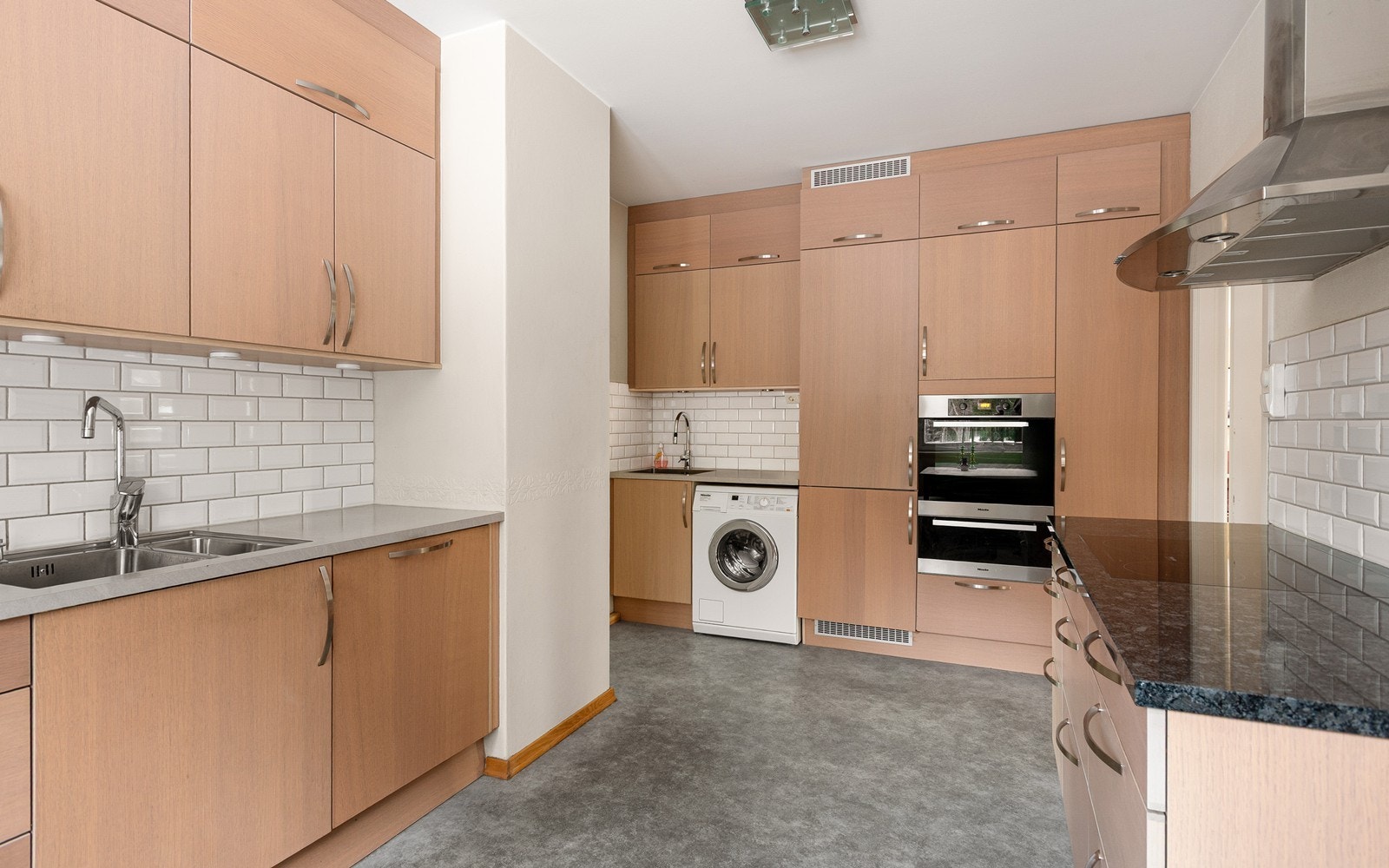 Gjennomgående kjøkken med koselig spiseplass ved vindu ut mot skogen, diverse integrerte hvitevarer og innredning fra HTH (plass til vaskemaskin og grovvask har du også) Galleribilde