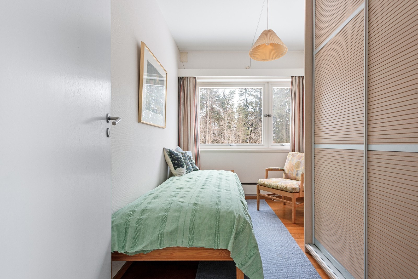 Soverom nr 3 med takhøye skap og utsikt mot skogen Galleribilde