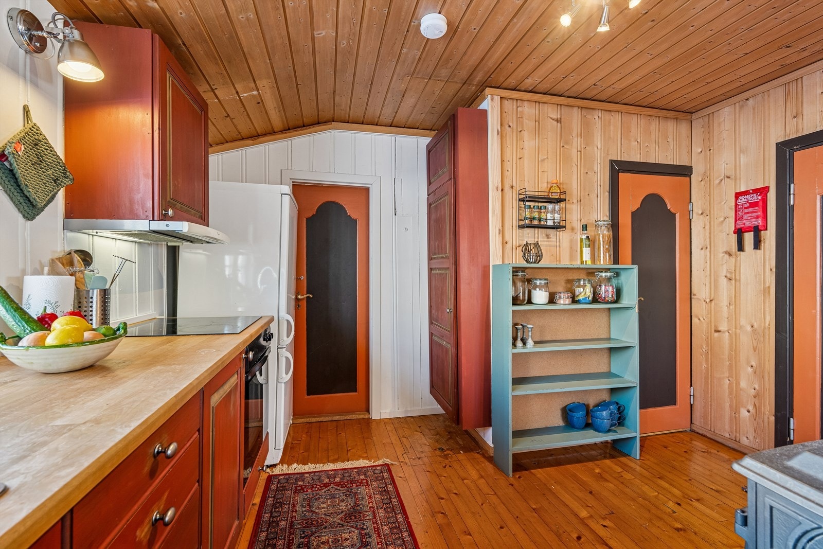 Det hyggelige kjøkkenet ligger i delvis åpen løsning med stua. Innredningen er i aldringsmalt heltre med over- og underskap, heltre benkeplate og oppvaskkum med kran av stål. Galleribilde