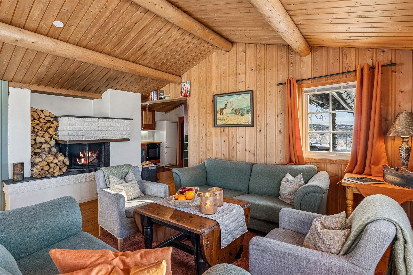 En hvit, stilren peis er med på å gi den perfekte hyttestemningen. Galleribilde