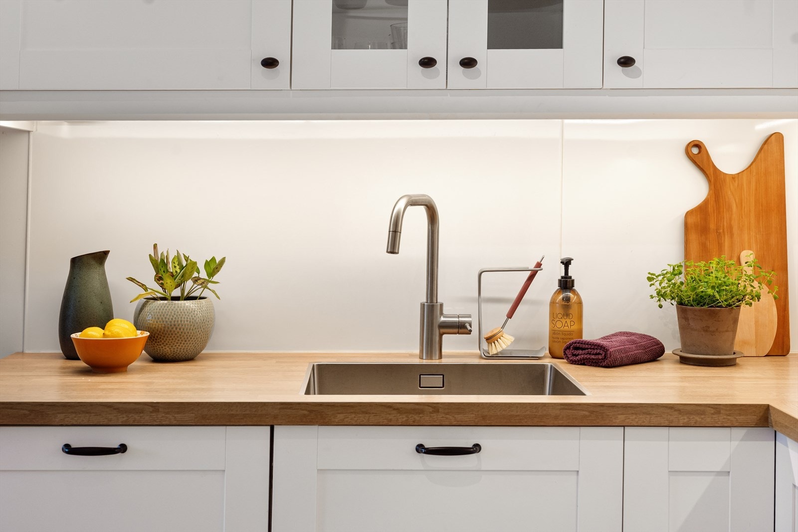 Kjøkkenet fra 2017 har en solid laminatbenkeplate med nedfelt kum i rustfritt stål. Galleribilde