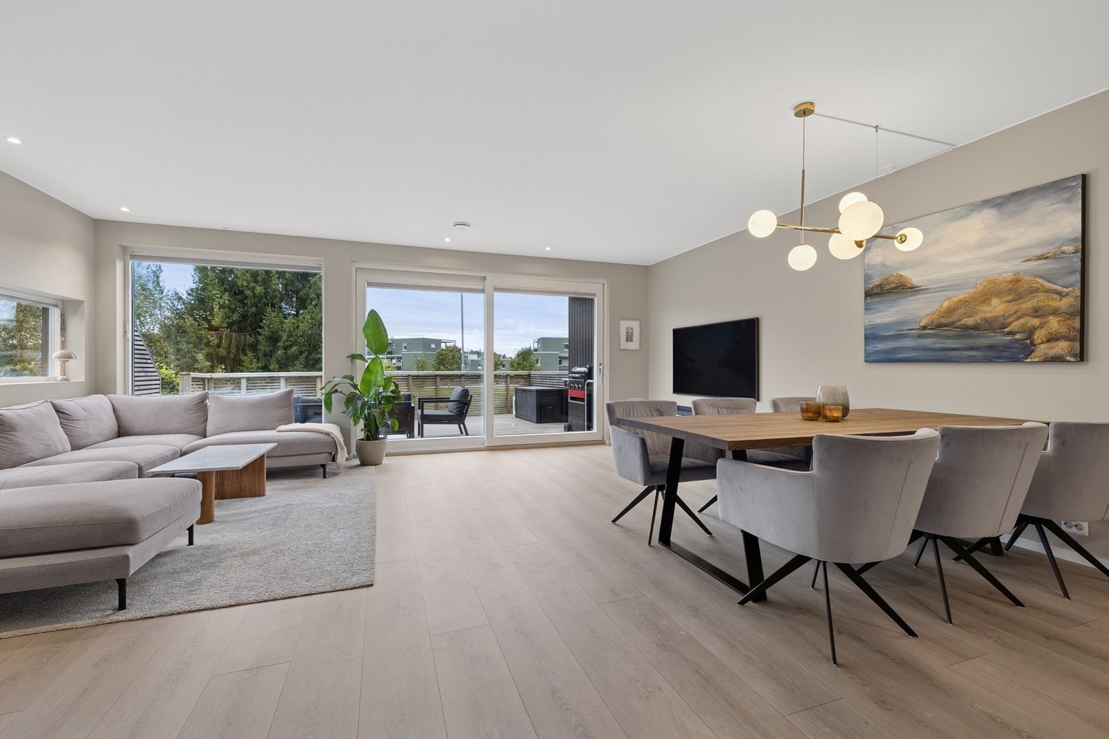 Rommet sørger for plass til en stor sofagruppe, TV og en hyggelig spisegruppe. Galleribilde