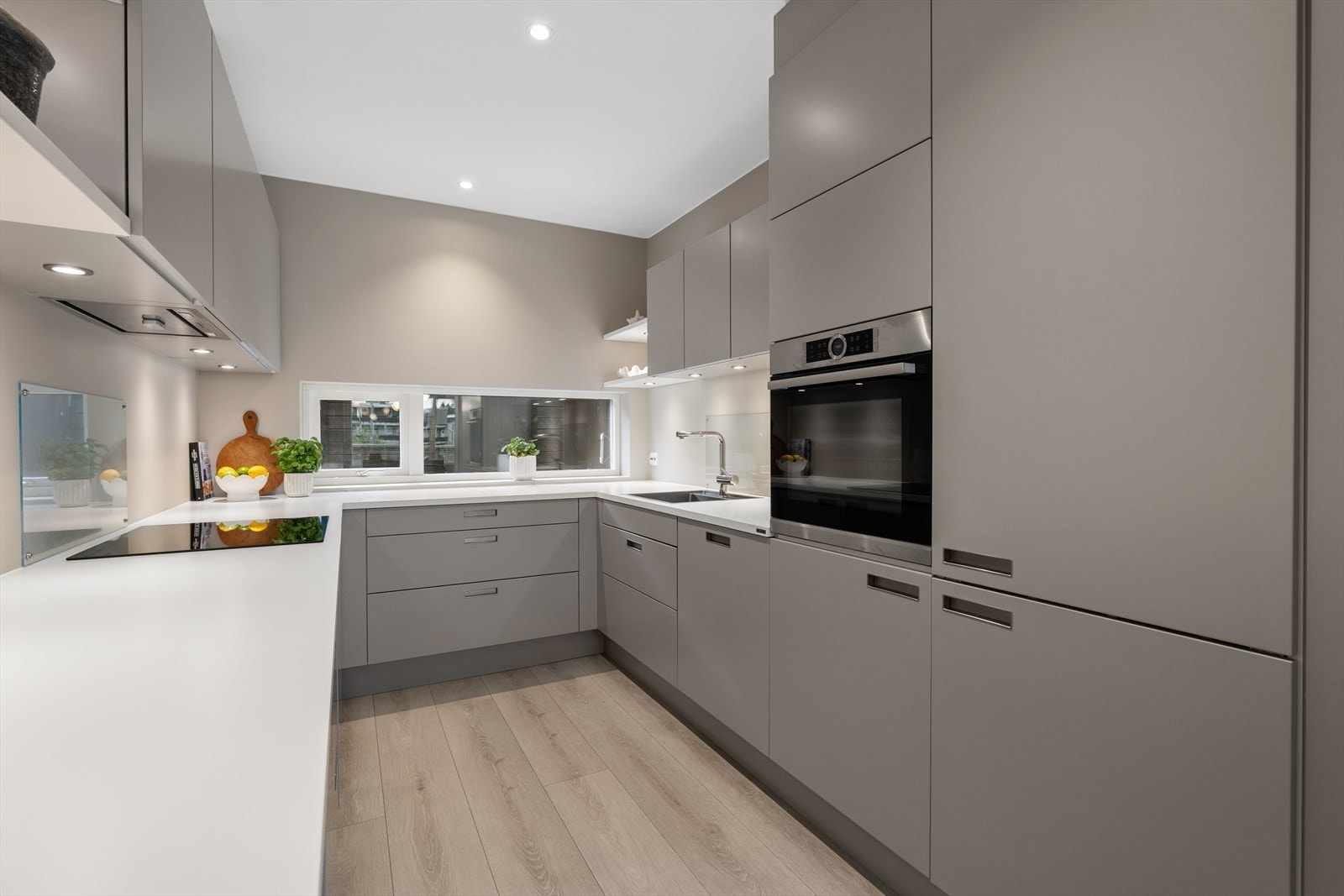 Moderne innredning fra 2020 med glatte fronter og benkeplate i laminat med oppvaskkum og blandebatteri. Galleribilde