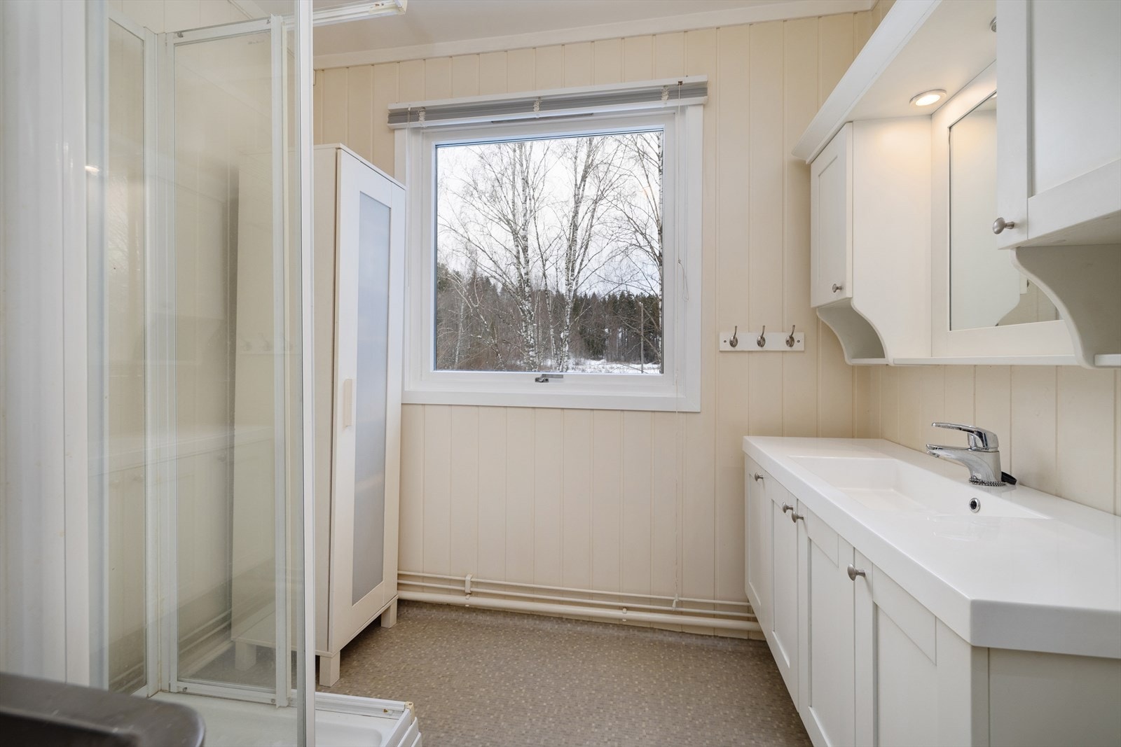 Badet er utstyrt med dusjkabinett, servantinnredning og speilskap med belysning. Galleribilde