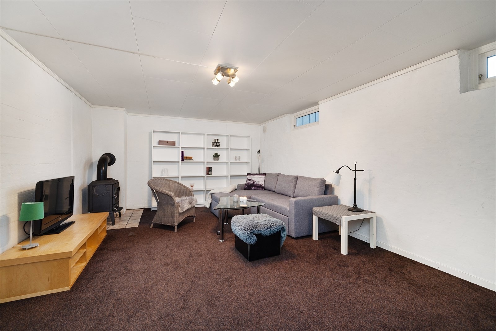 Innredet rom i kjelleren med eget ildsted. Vinduene her ble byttet i 2011. Galleribilde