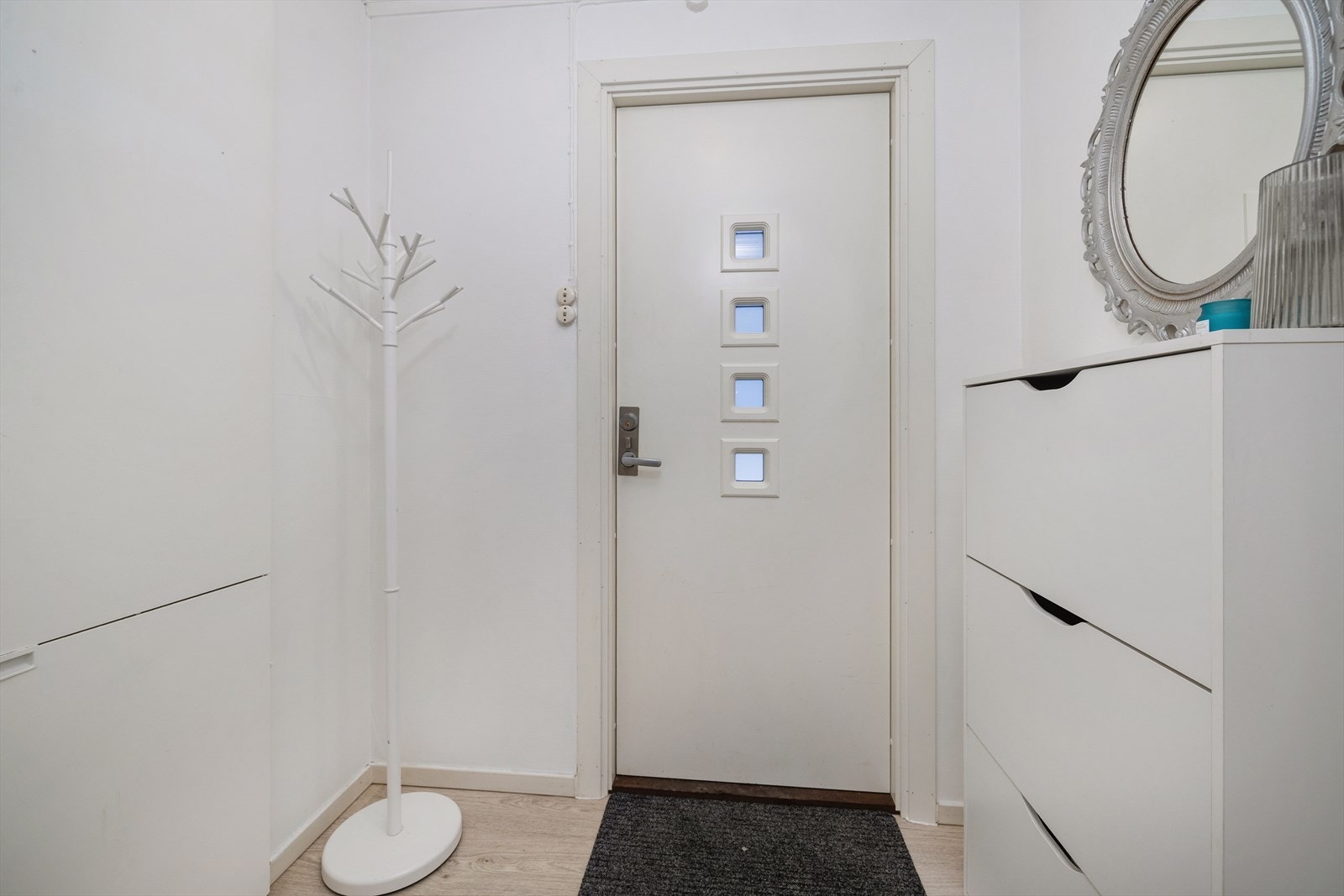 En lys entré ønsker velkommen inn i boligen. Galleribilde