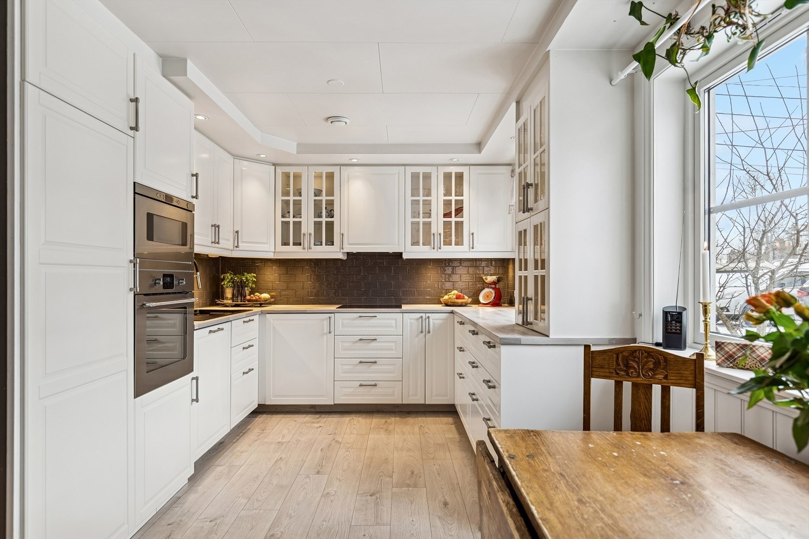 Kjøkkenet fra 2016 har en smart L-form med rikelig skap- og benkeplass. Utenfor kjøkkenvindu er det plantet plommetre og morelltre som blomstrer i nydelige farger på våren. Galleribilde