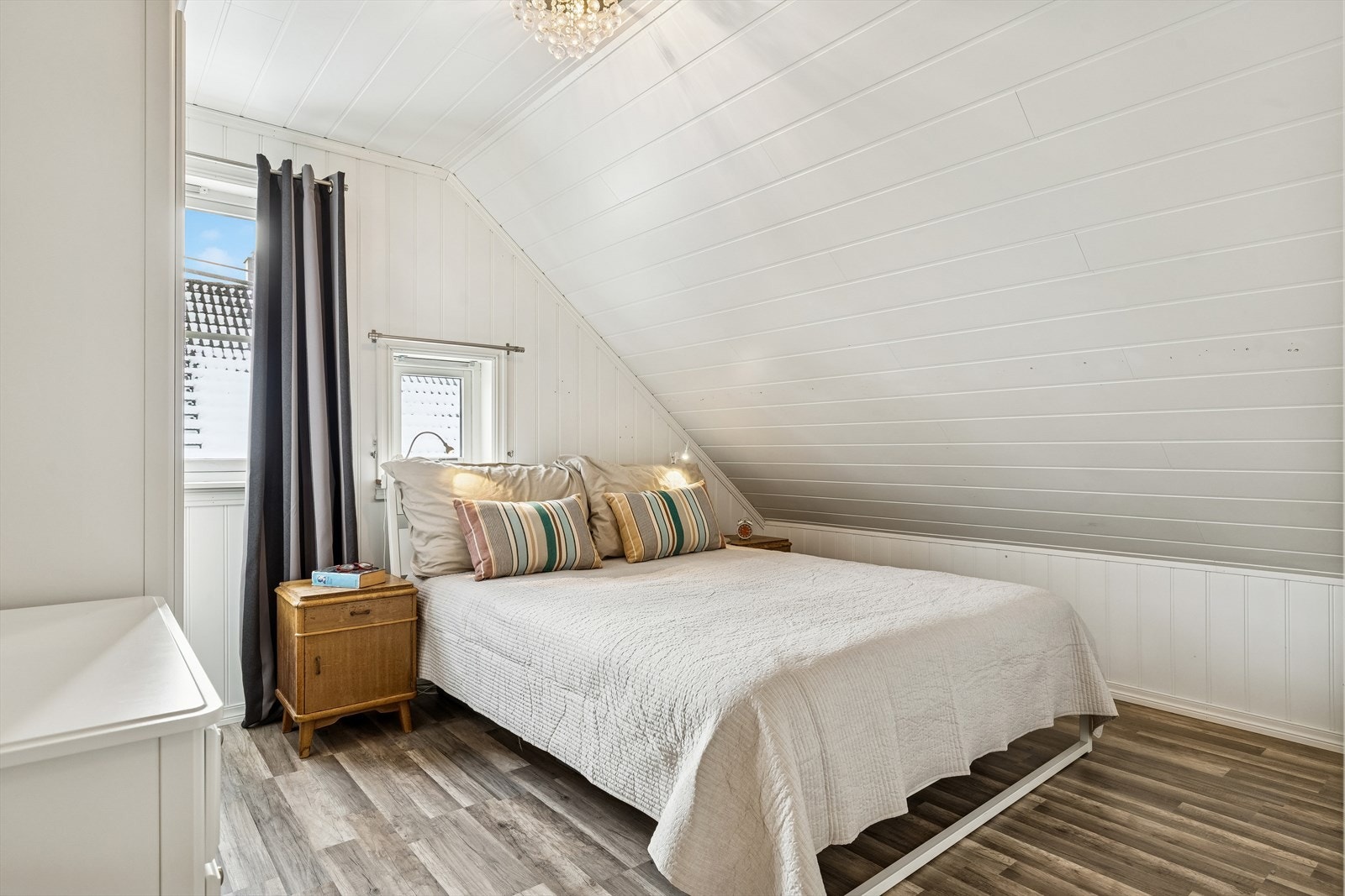 Et av de tre soverommene i andre etasje, med laminatgulv og malte panelplater. Galleribilde