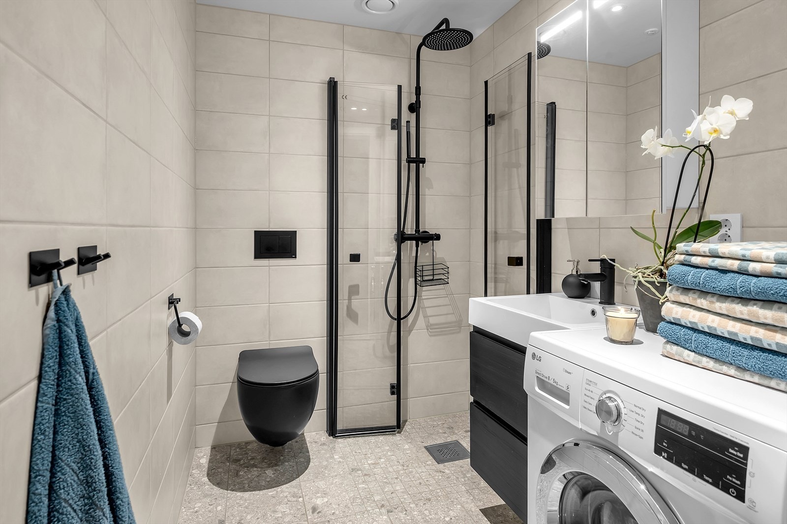 Lekkert flislagt baderom med naturfargede fliser og gjennomførte sorte detaljer Galleribilde