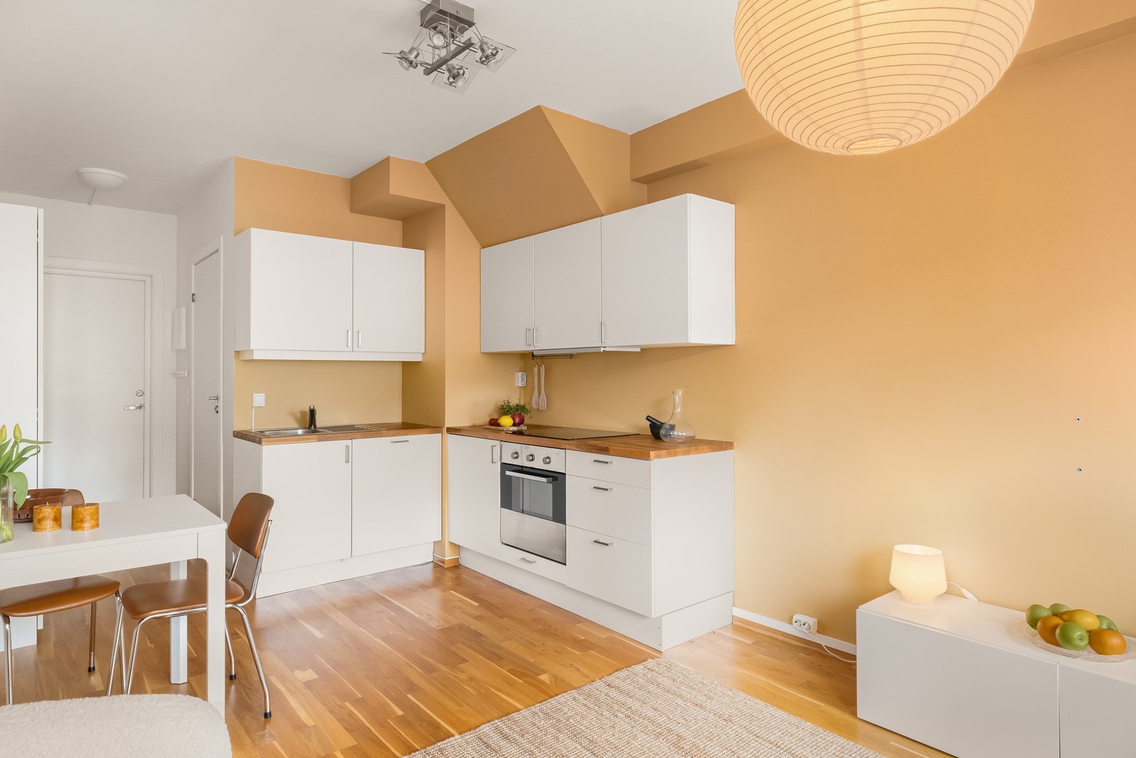 Pent kjøkken med slette fronter og heltre benkeplate Galleribilde