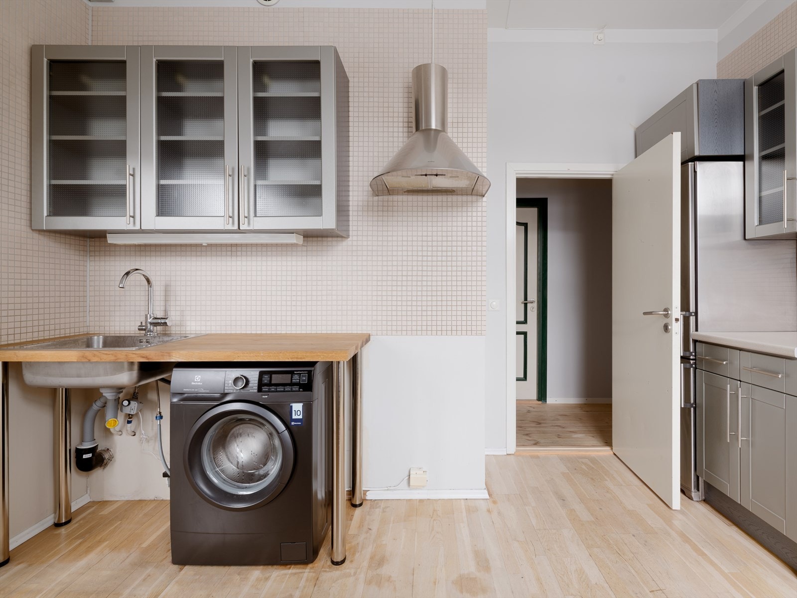 Den luftige takhøyden gir rom for overskap helt opp og smarte oppbevaringsløsninger som virkelig maksimerer kjøkkenet. Galleribilde