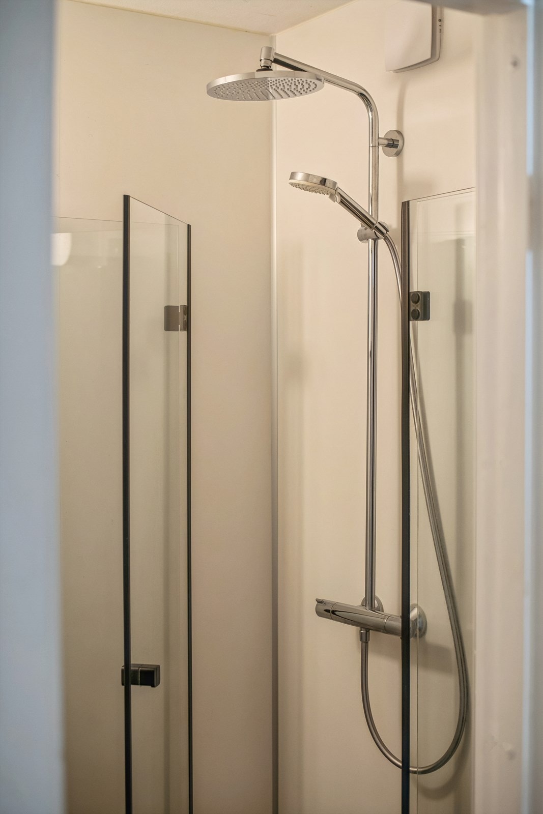 Dusjhjørne med plassbesparende, innfellbare glassdører. Galleribilde