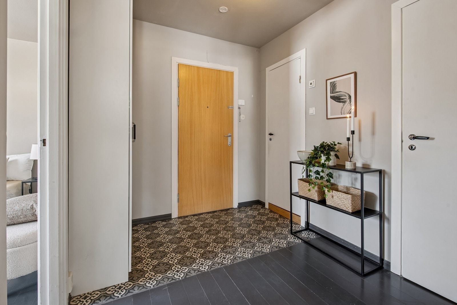 Inngangspartiet har dekorative fliser på gulvet og et praktisk garderobeskap rett innenfor døren. Galleribilde