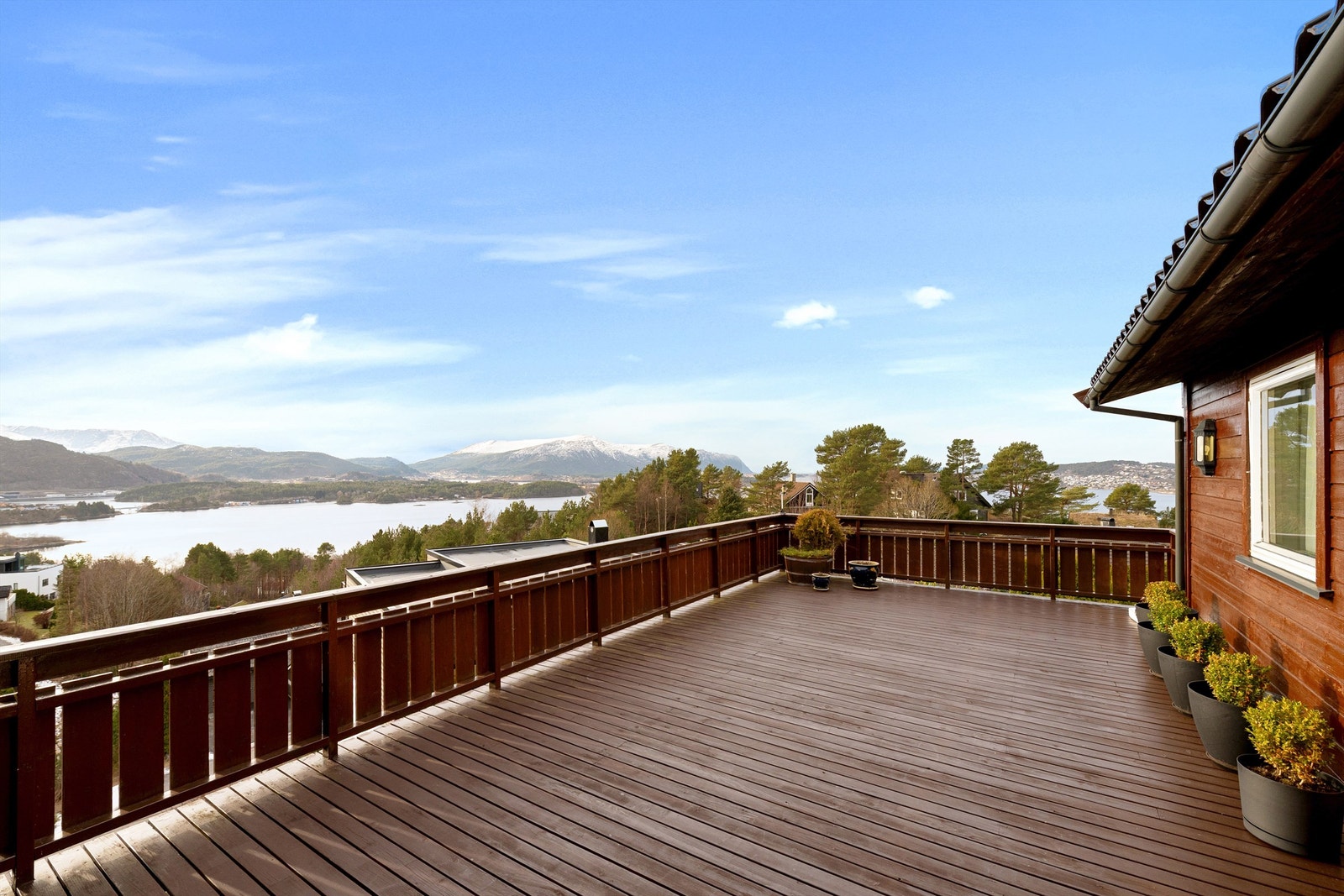 Terrasse på 38 kvm med praktfull utsikt mot fjord og fjell. Utgang fra stue i hovedetasjen samt fra tv-stue/soverom Galleribilde