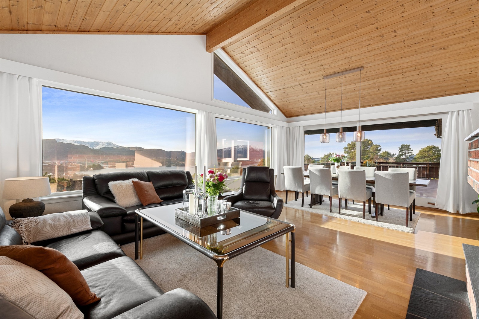 Stue i hovedetasjen med god takhøyde og store vindusflater som gir godt med naturlig lysinnslipp samt praktfull utsikt Galleribilde