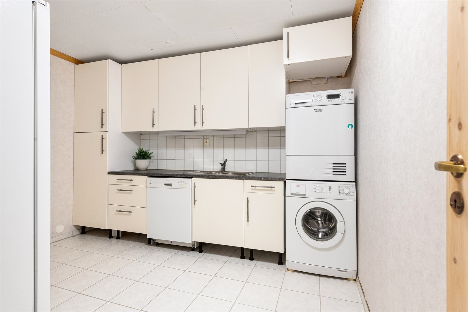 Vaskerommet er fra ca. 2001 og har flislagt gulv med gulvvarme. Innredning fra ca. 2009 med glatte hvite fronter og laminat benkeplate med nedfelt skyllekum og flisplater på vegg over benken. Opplegg for vaskemaskin, tørketrommel og oppvaskmaskin. Galleribilde