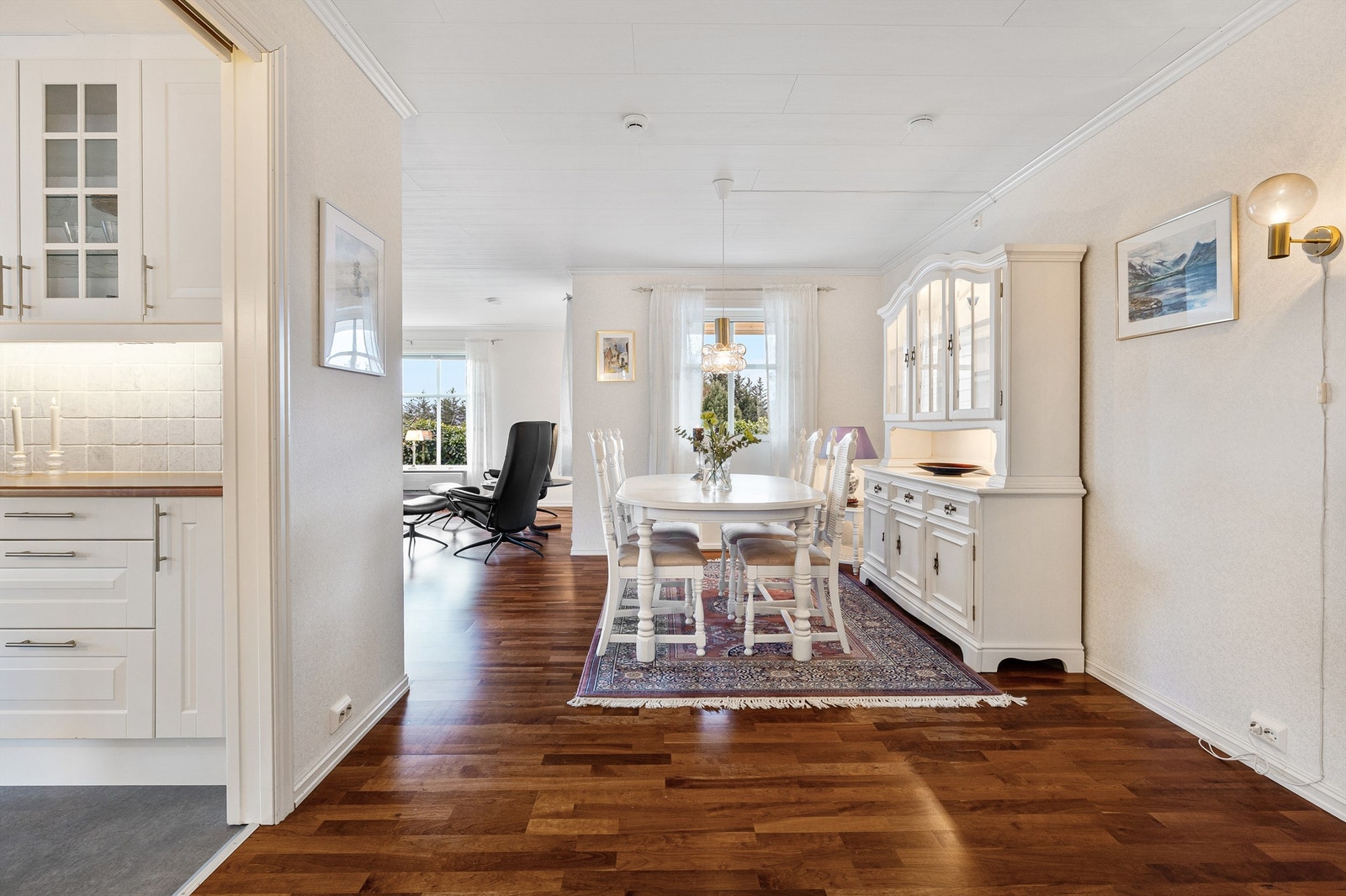 Lys og romslig stue med parkettgulv og åpne soner mot spiseplass. Galleribilde