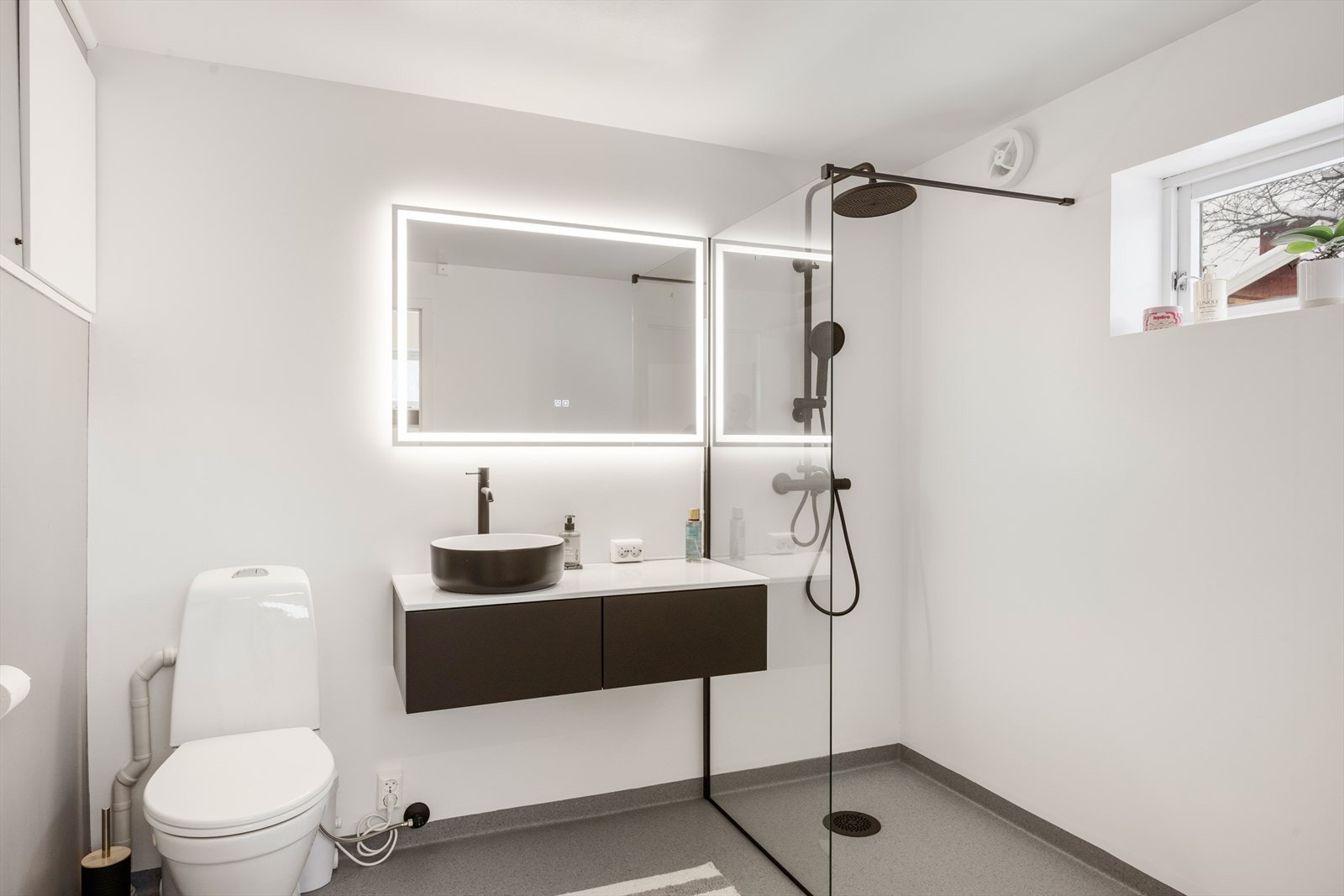 Nytt baderom som er innredet med servant, gulvmontert totalett og dusjvegger/hjørne. Galleribilde