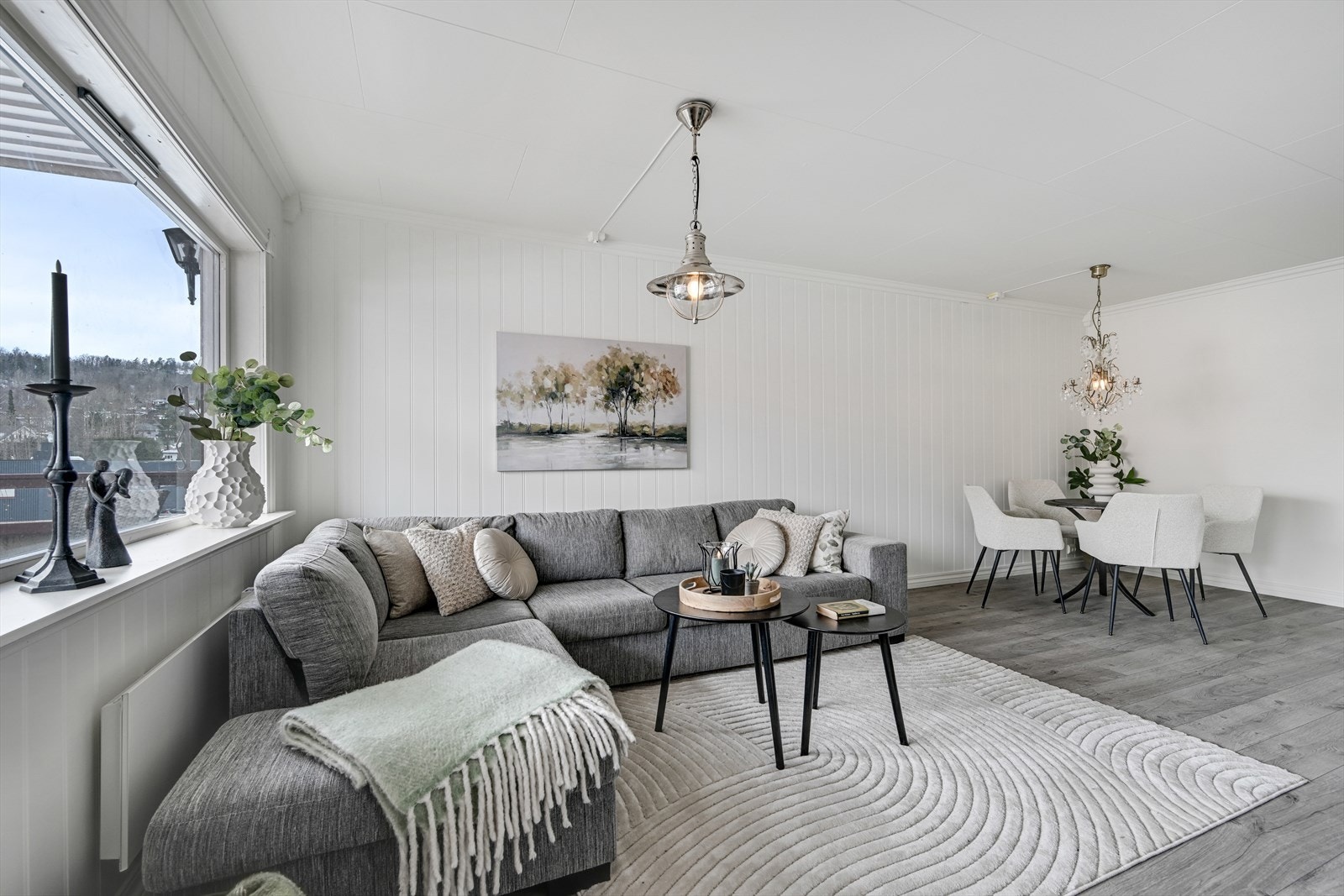 Stue/spisestue med laminat på gulv, malt panel på veggene og takess i tag. Galleribilde