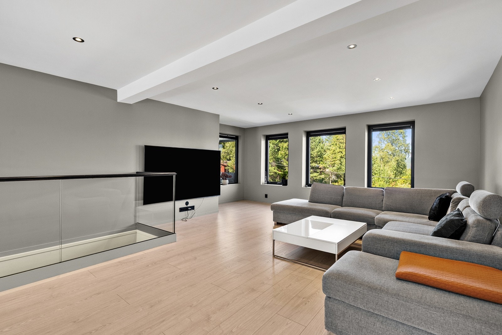 Lys og moderne stue med store vindusflater som gir flott utsyn og godt lysinnslipp. Rommet har en åpen og luftig planløsning med god plass til både sofakrok og tv-løsning. Galleribilde